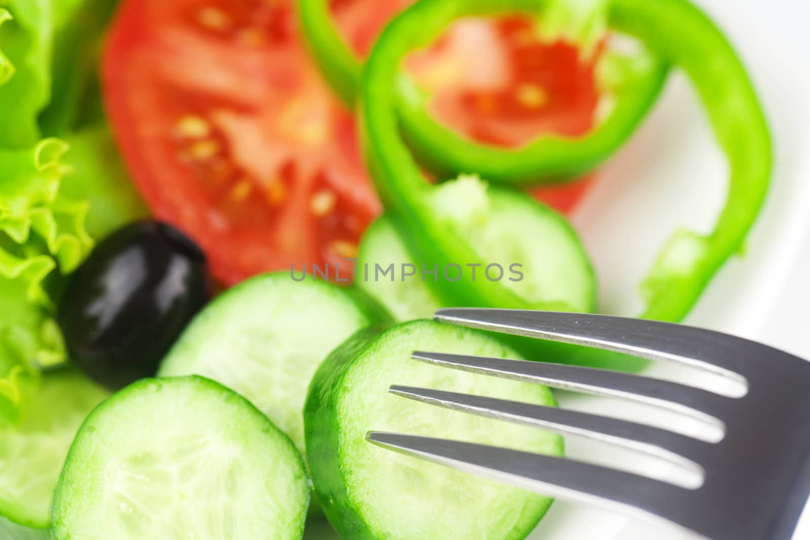 fork,black olive,lettuce, tomato, cucumber and pepper in a bowl by jannyjus