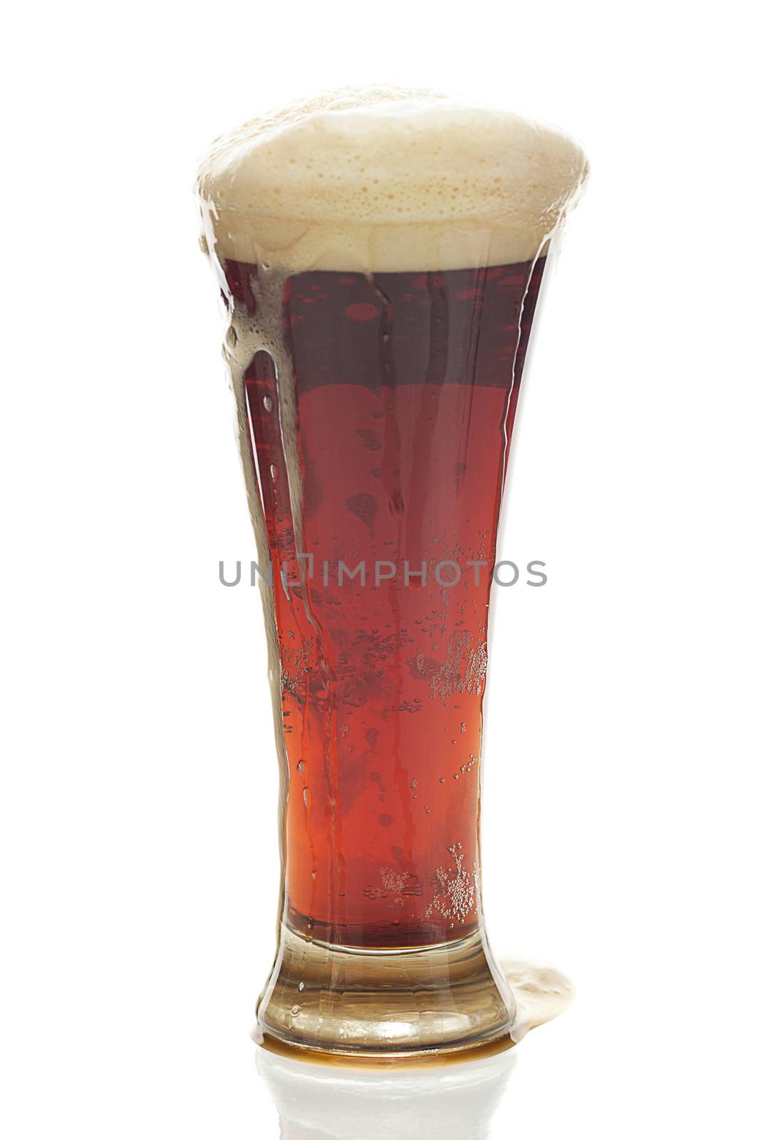 dark beer with the foam in a tall glass isolated on white