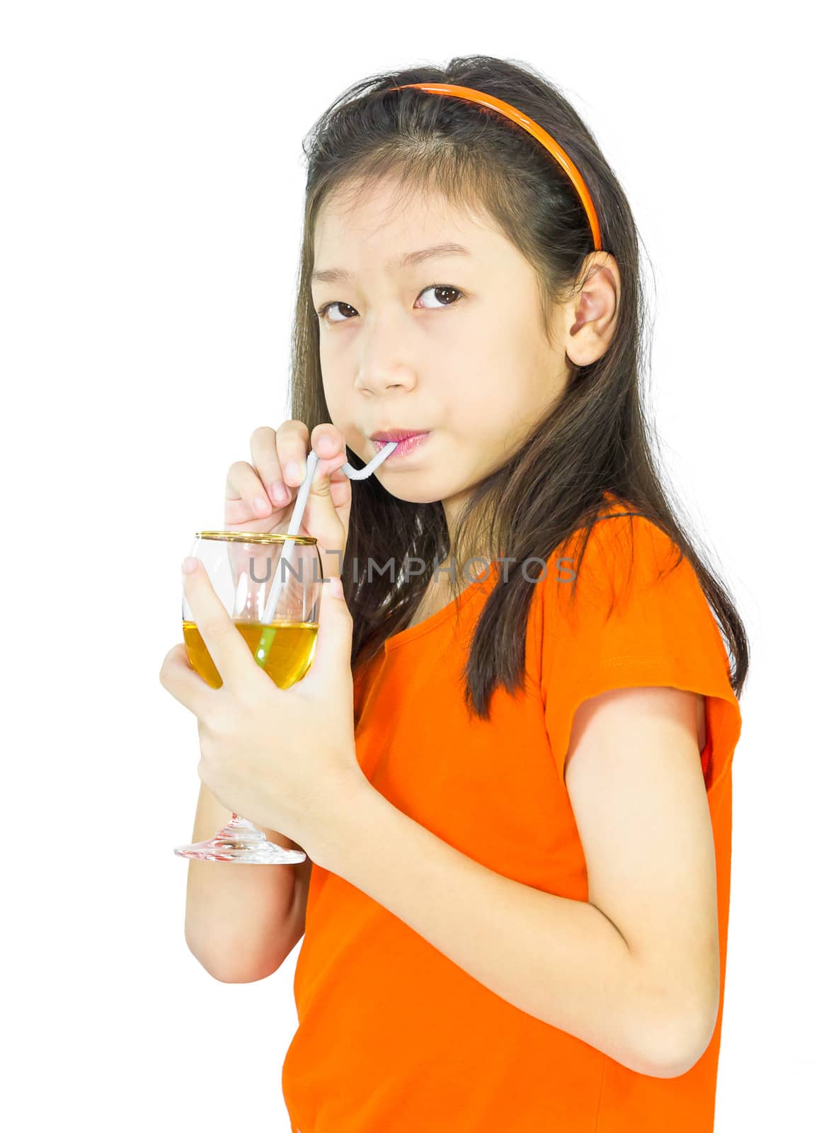 Asian young girl drinks orange juice using a drinking straw, isolated over white