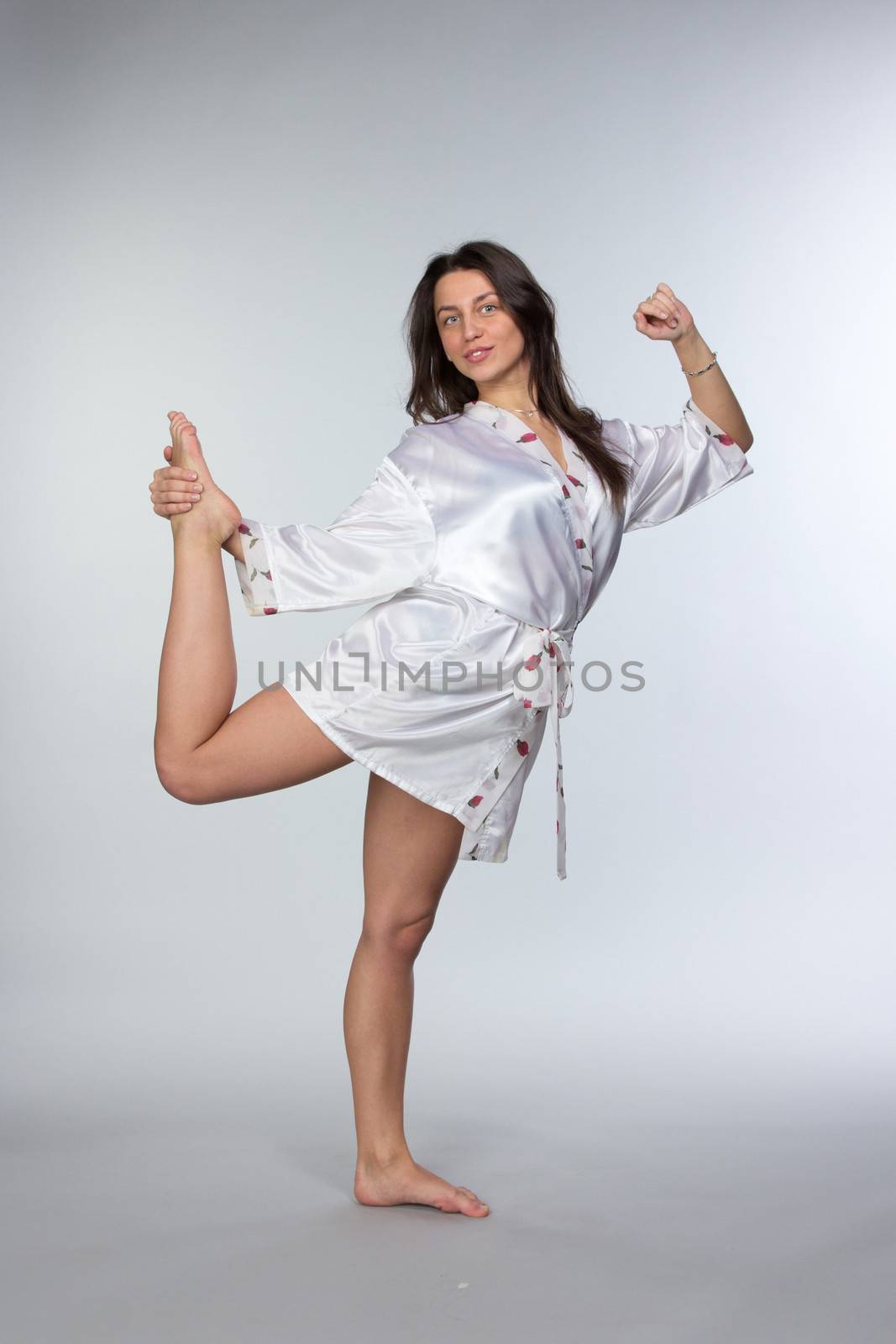 Young beautiful brunette in peignoir isolated on white background