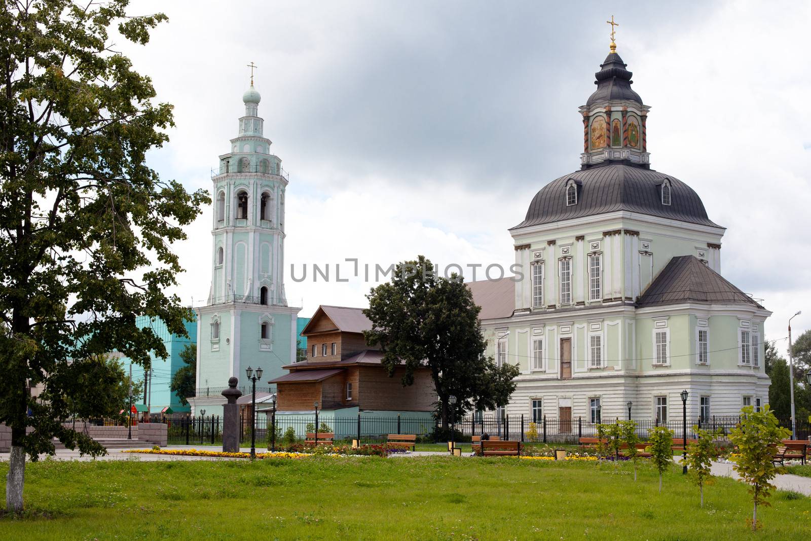 White and green orthodox church with grey domes
