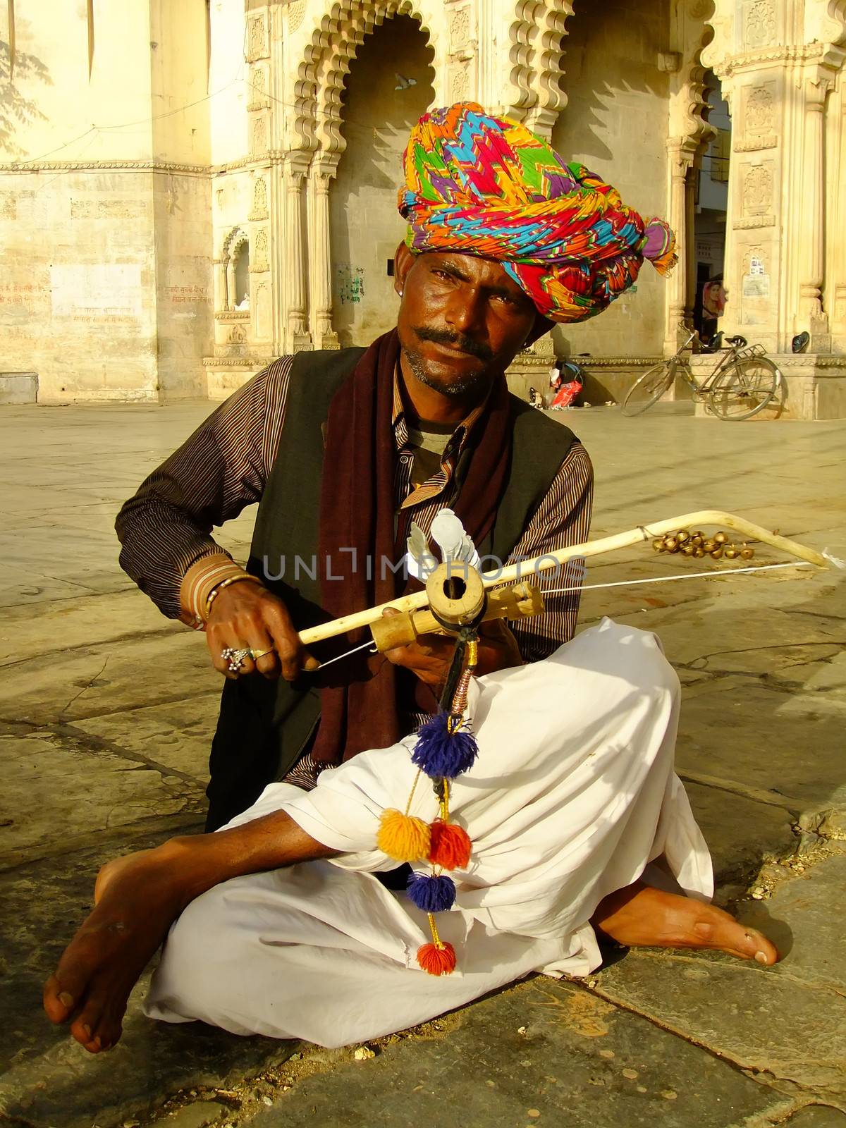 Indian man playing ravanahatha at Lake Pichola, Udaipur, India by donya_nedomam