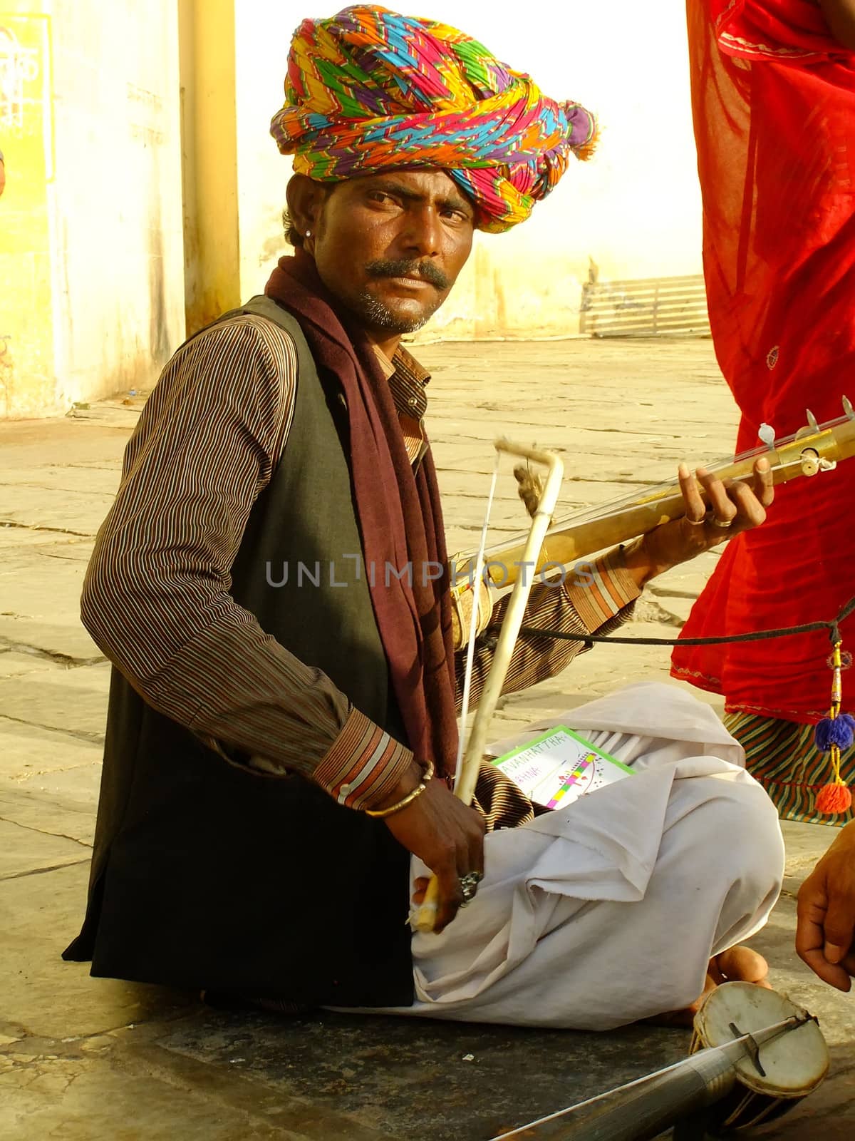 Indian man playing ravanahatha at Lake Pichola, Udaipur, India by donya_nedomam