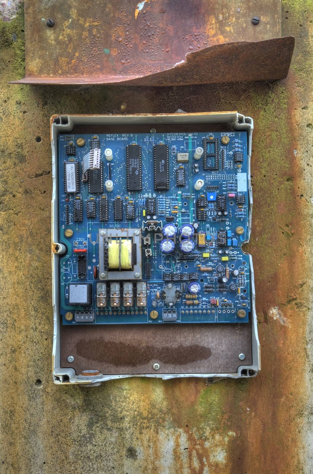 Kidderminster, Worcestershire, UK ��� January 26, 2009: Battered old circuit board on rust-stained concrete at a disused factory.