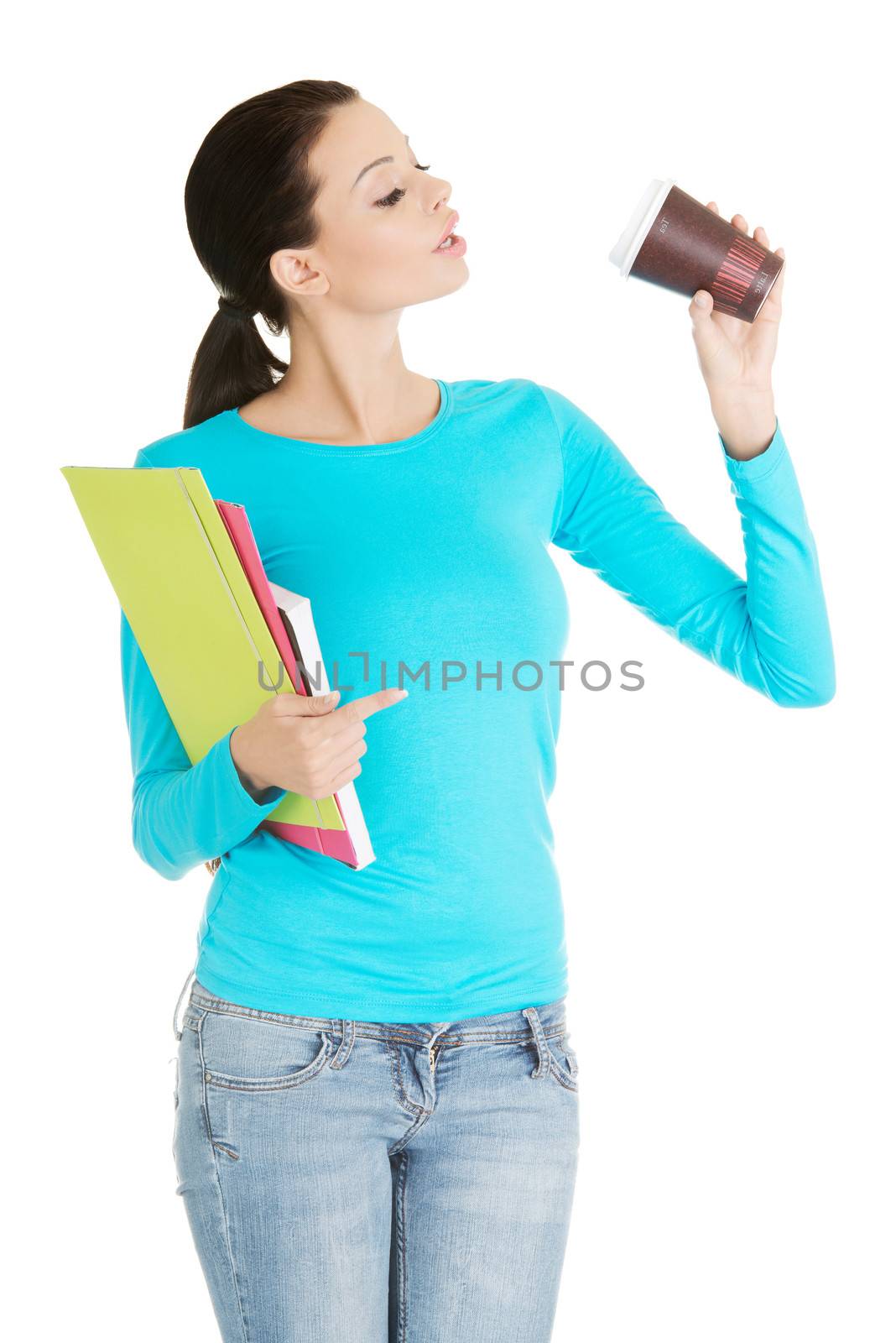 Young student or businesswoman with notebooks drinking coffee or tea from paper mug