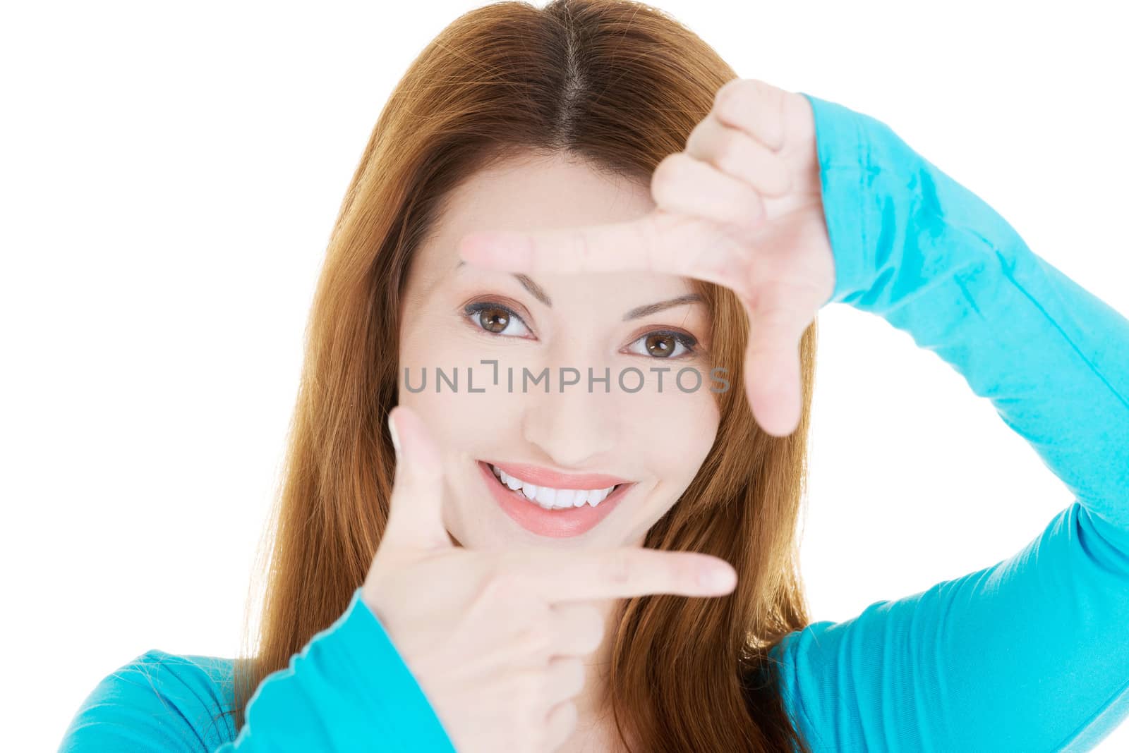 Smiling woman wearing blue blouse is showing frame by hands. by BDS