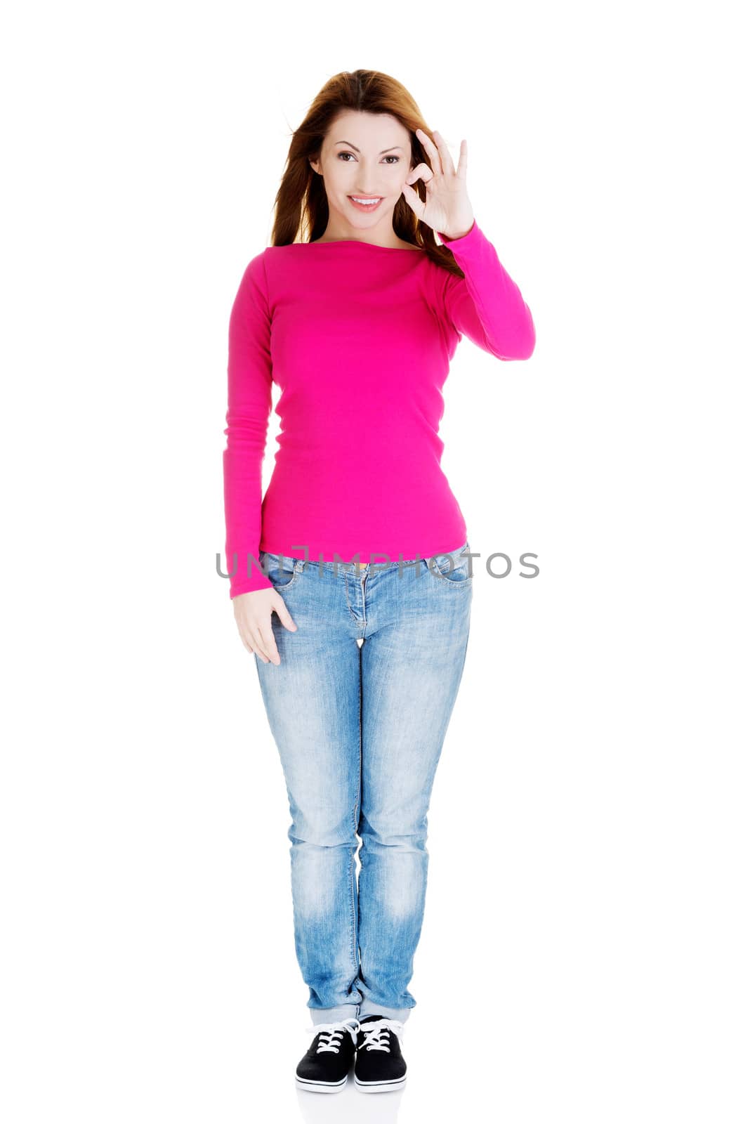 Beautiful success woman giving perfect gesture standing on white background.