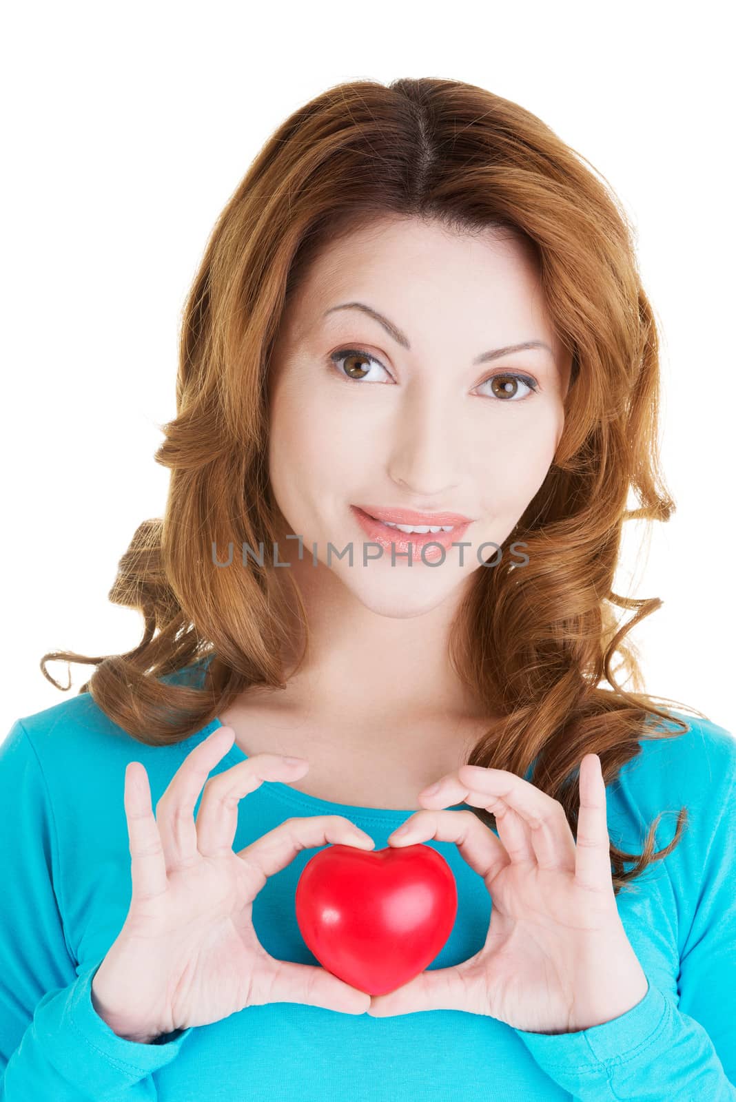 Attractive smiling woman showing red heart toy