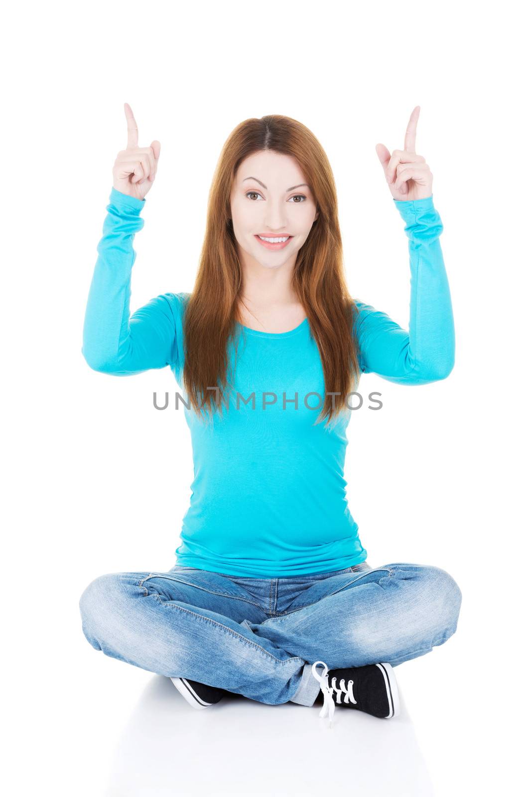 Happy , excited young woman pointing on copy space, isolated on white