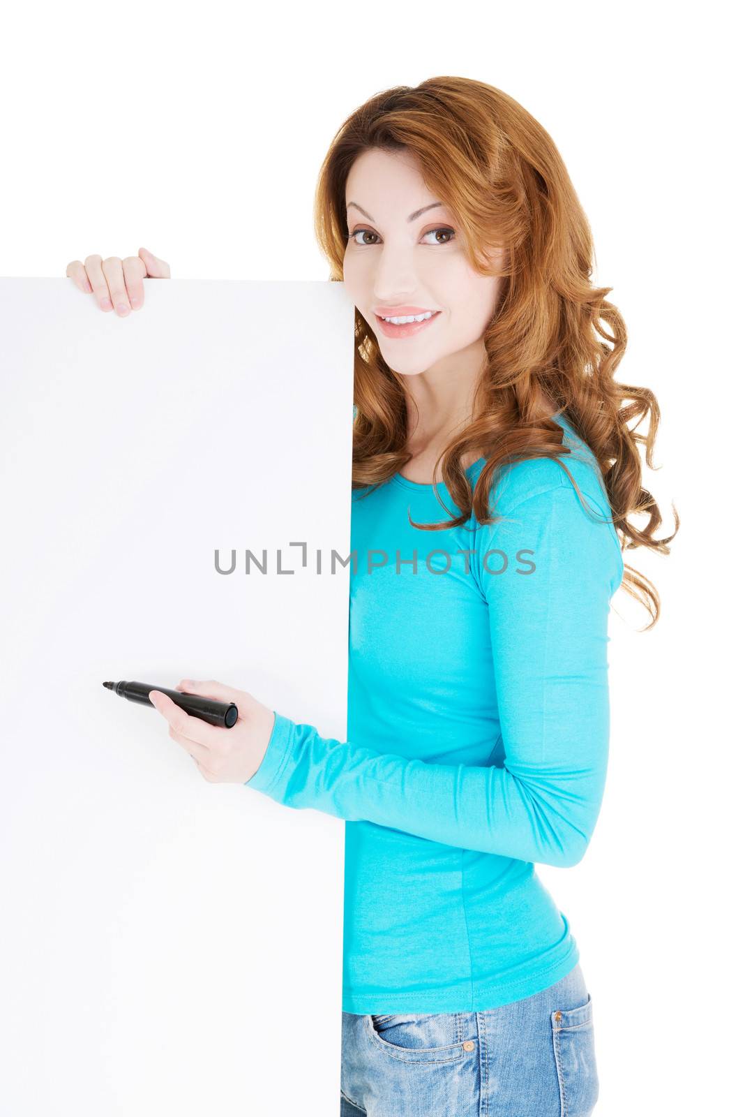 Happy beautiful woman writing with a marker on blank board. Student, teacher or businesswoman.