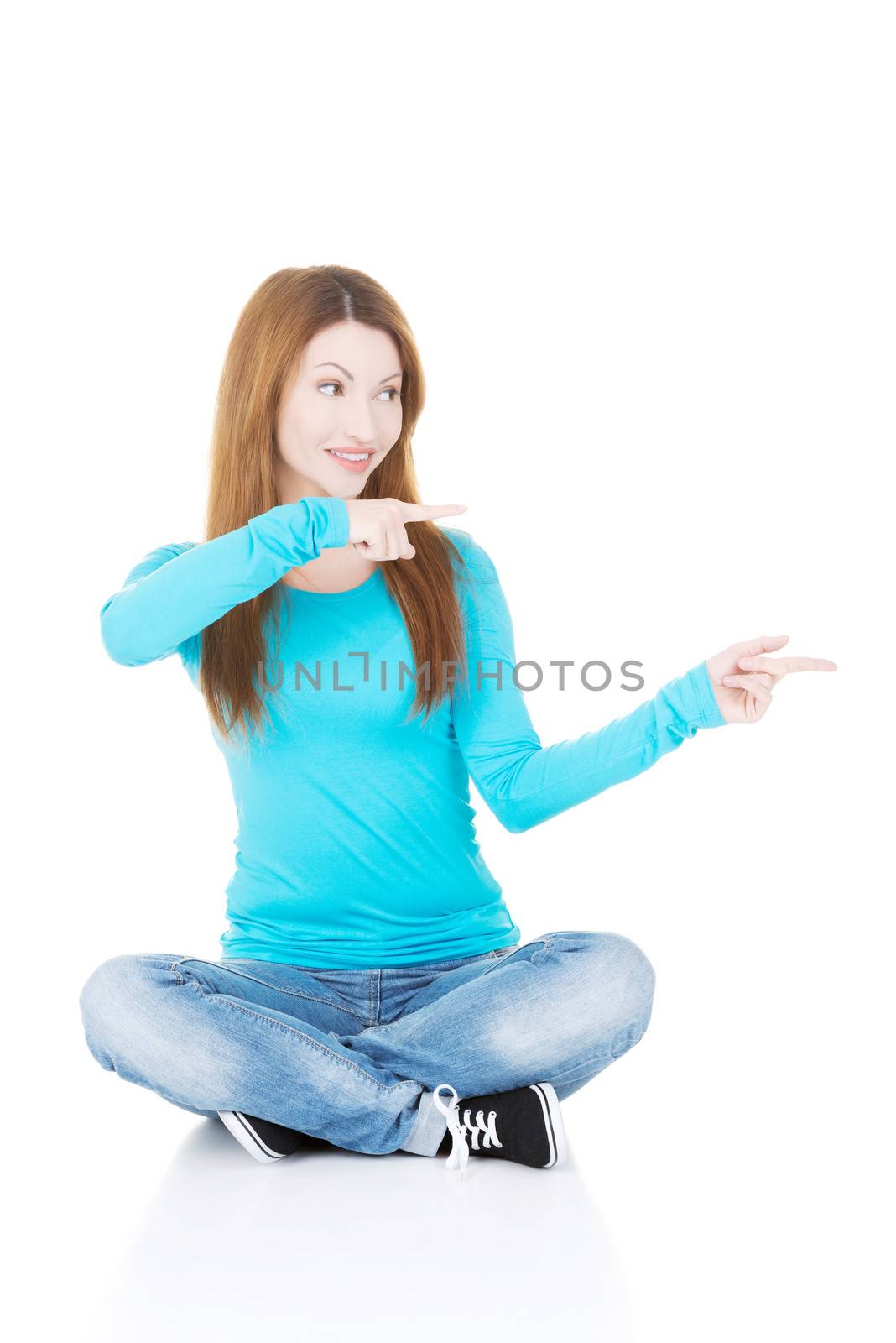 Happy , excited young woman pointing on copy space, isolated on white