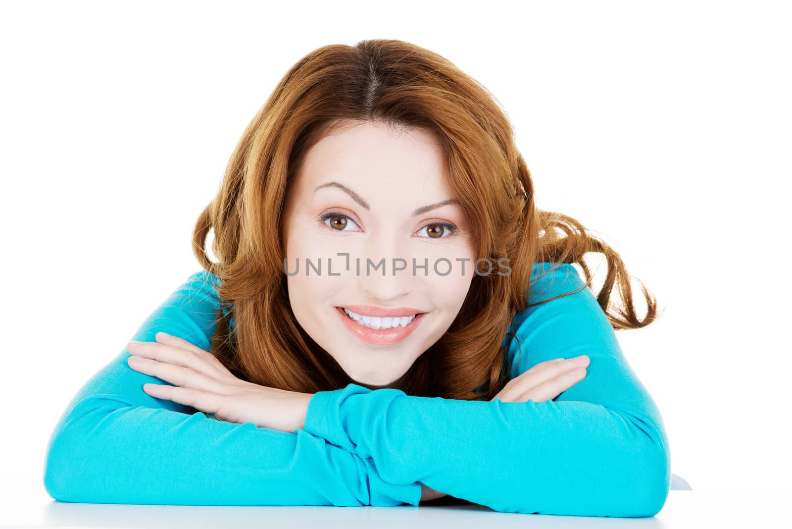 Pretty, happy woman in casual clothes sitting at the desk by BDS
