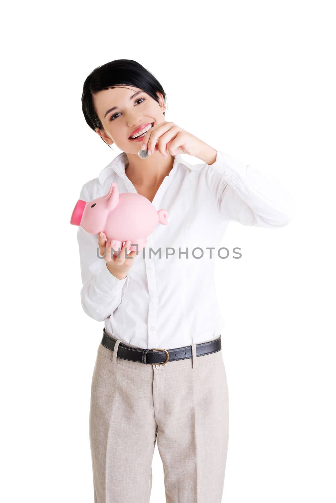 Businesswoman putting a coin into a piggy bank by BDS