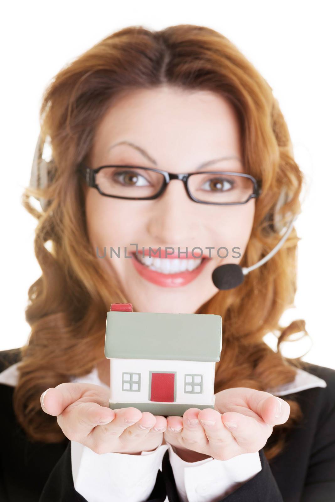 Attractive call center support woman with headset andhouse model in hands. Real estate concept.