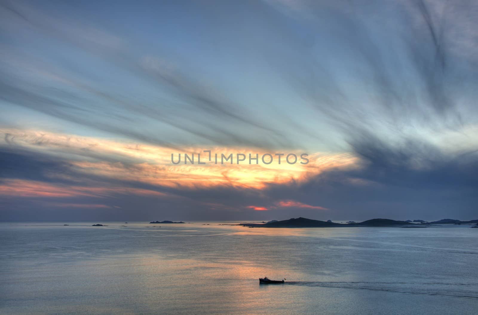 Lone boat passing Samson island at sunset from St Mary���s, Isles of Scilly, Cornwall, England.