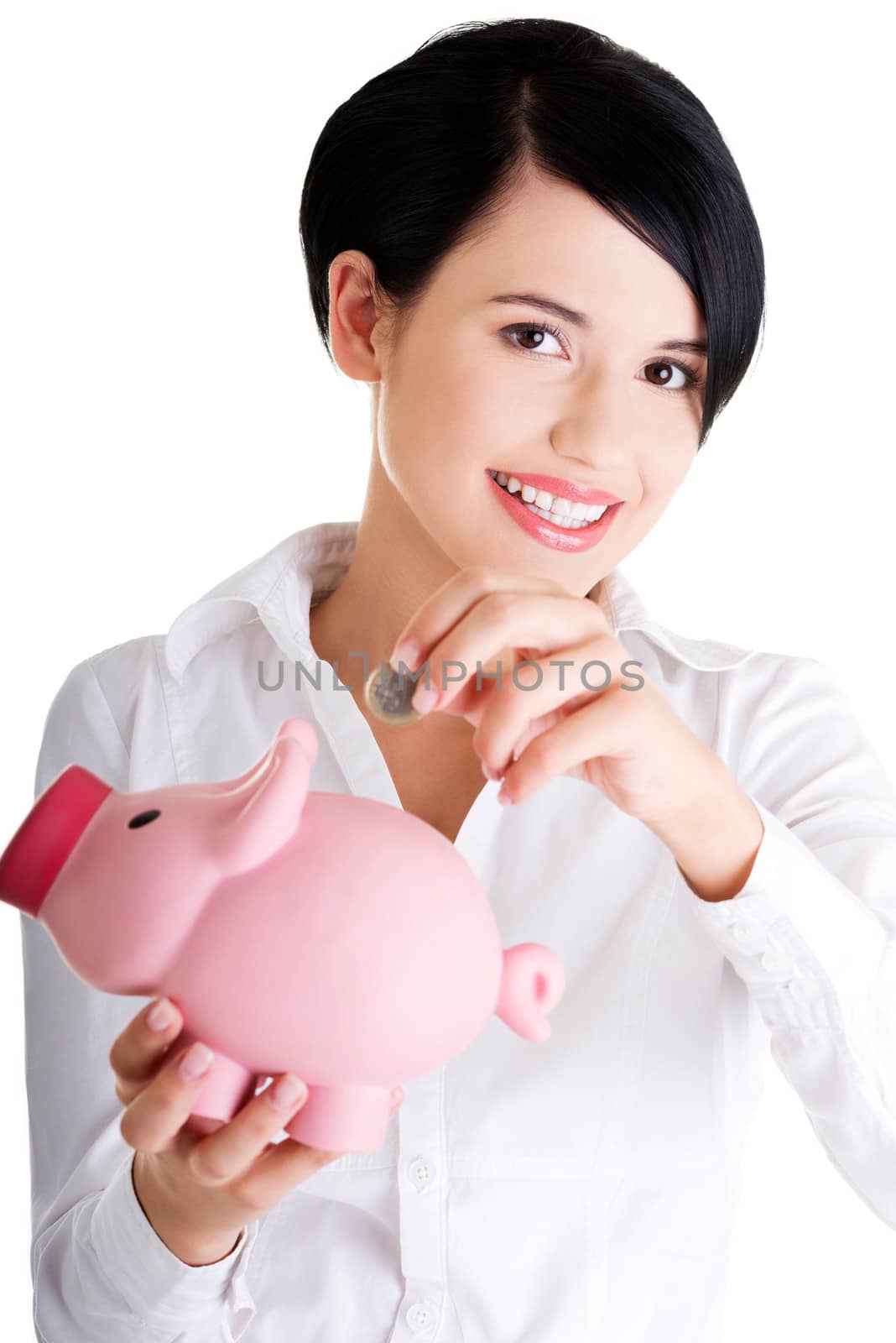 Happy businesswoman putting an euro coin into a piggy bank isolated on white background