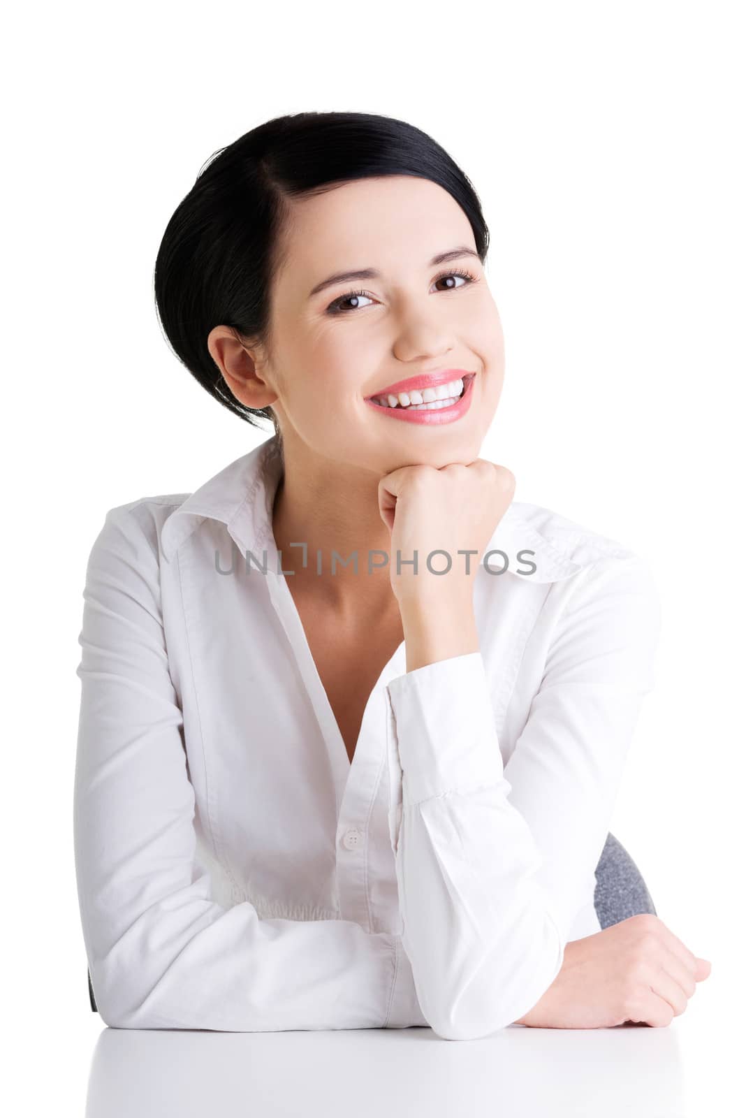 Young beautiful happy businesswoman behind the desk, isolated