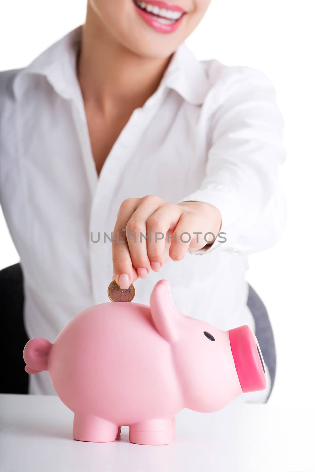Businesswoman putting a coin into a piggy bank by BDS