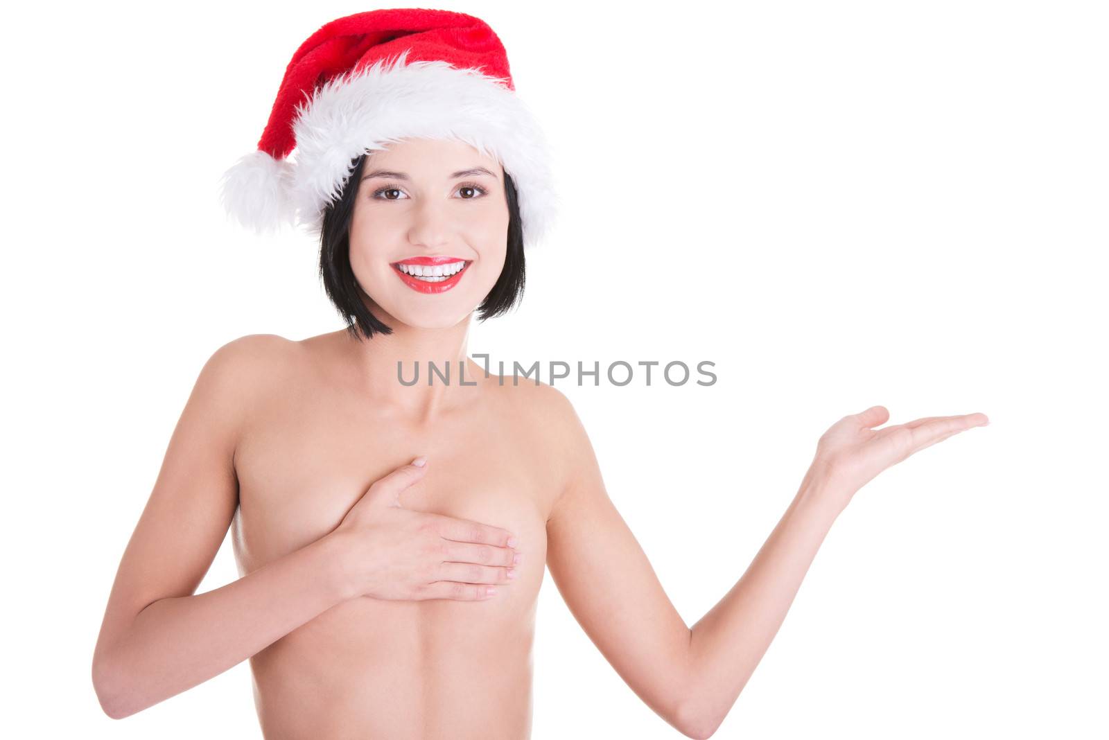 Sexy topless woman with perfect slim body wearing santa hat and showing on copy space.