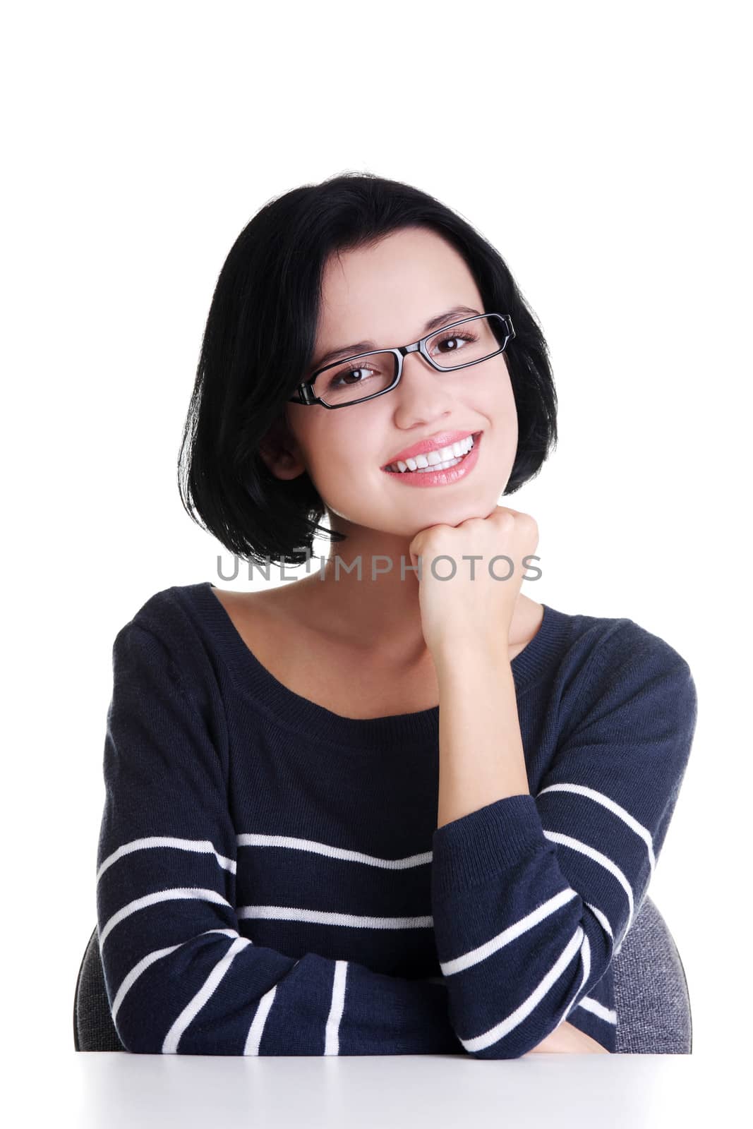 Smiling student girl sitting at the desk, isolated on white