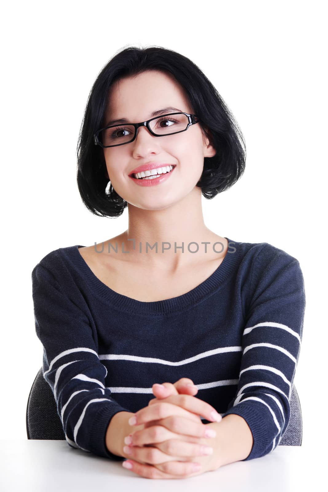 Smiling student girl sitting at the desk, isolated on white