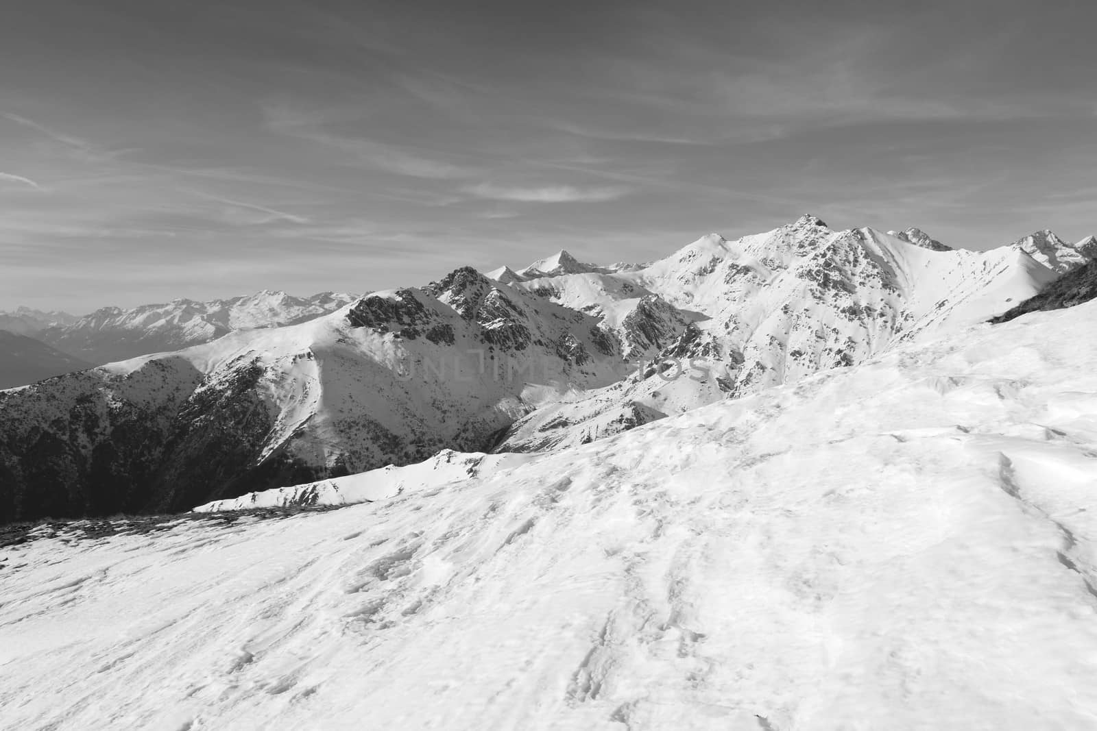 Candid off-piste ski slope in scenic background of mountain peaks, valleys and plain. Piedmont, Italian Alps