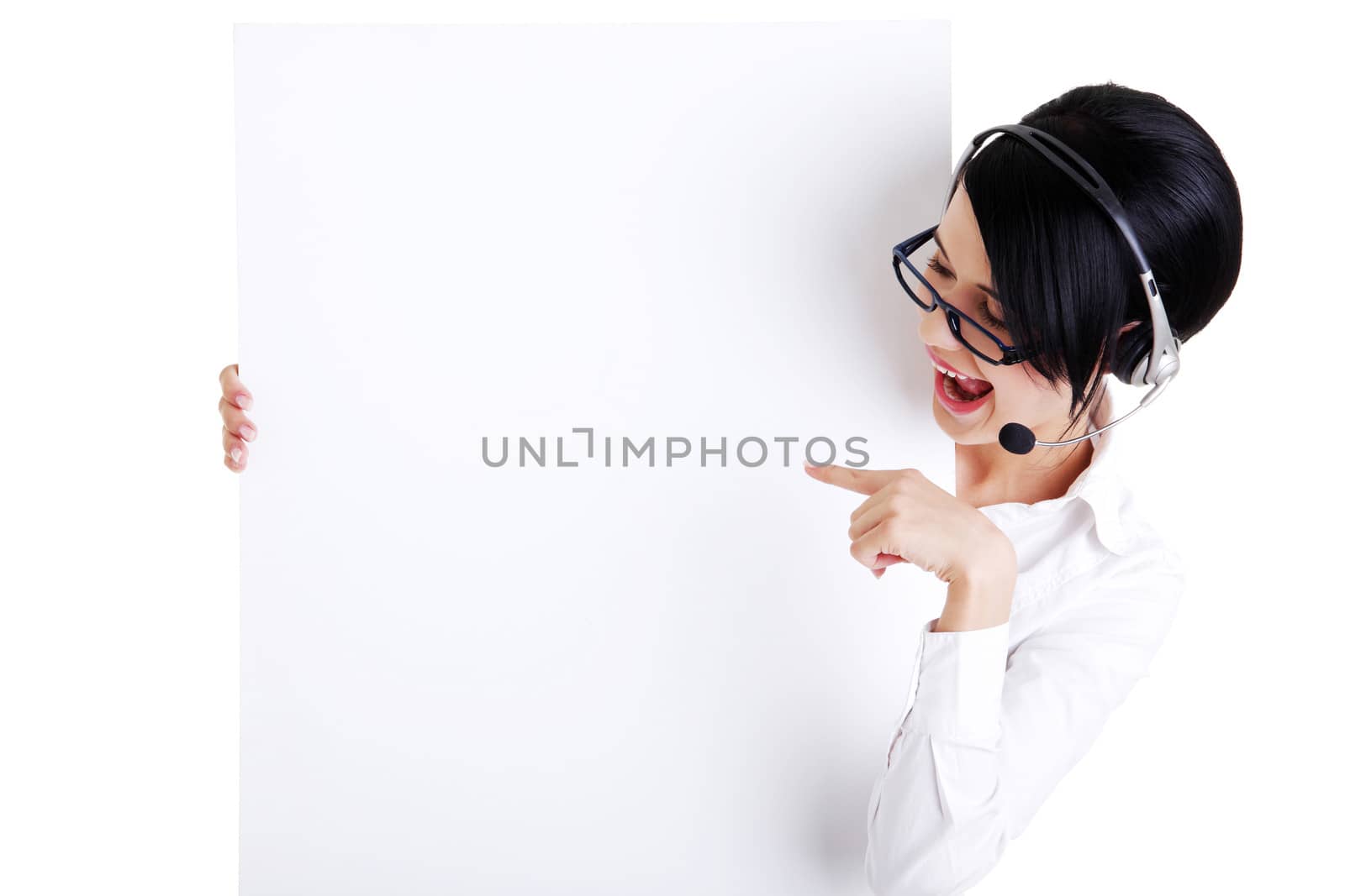 Pretty young call center worker wearing a headset and holding blank sign board