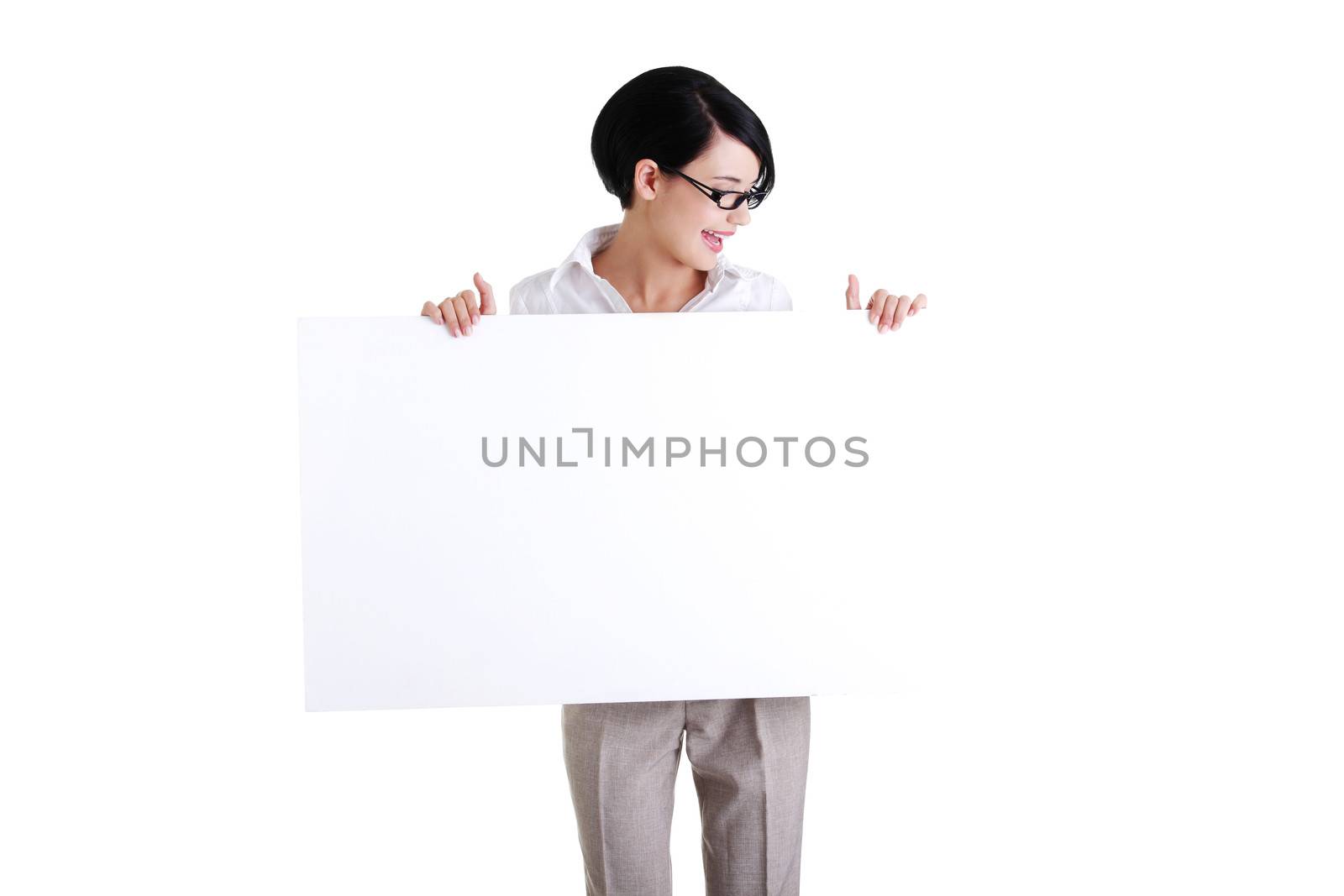 Smiling young business woman showing blank signboard, over white background isolated