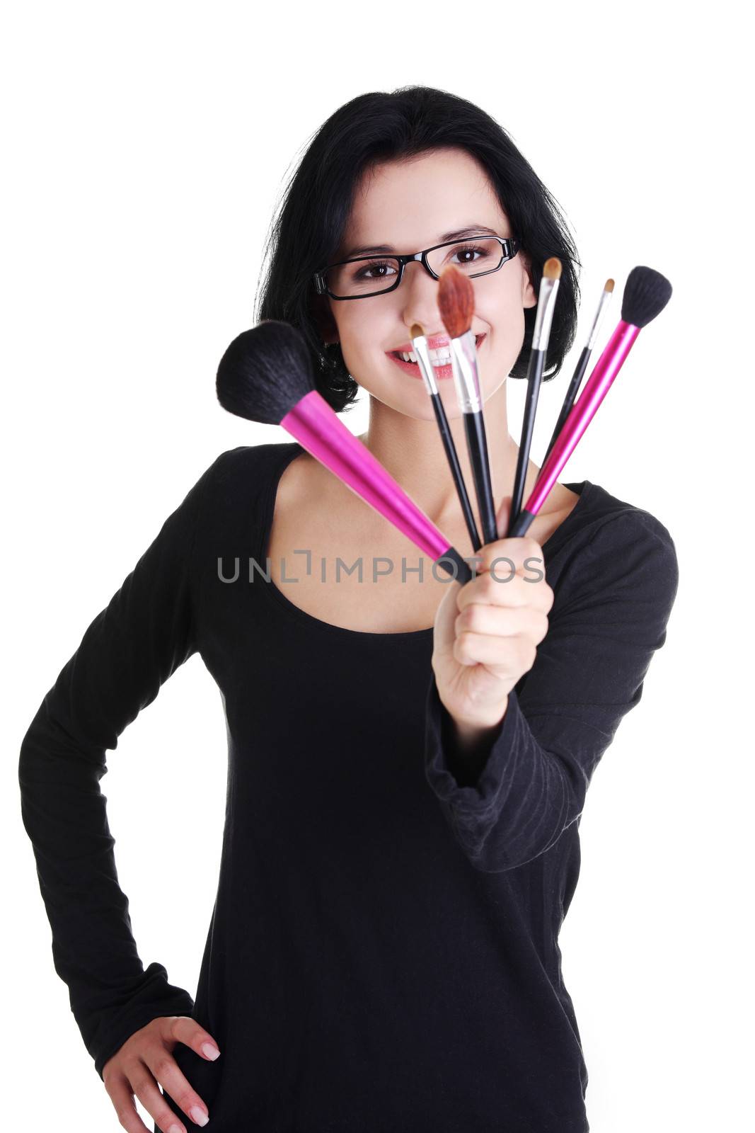 Young make-up artist woman holding brushes