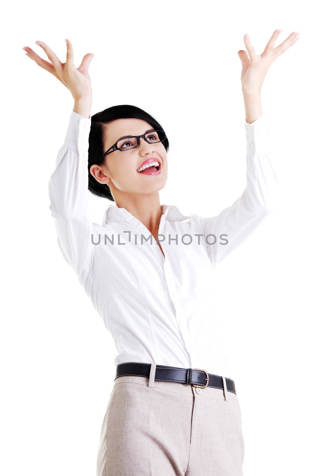 Smiling young woman is holding something abstract above her head. Happy girl with raised hands. Isolated on white background.