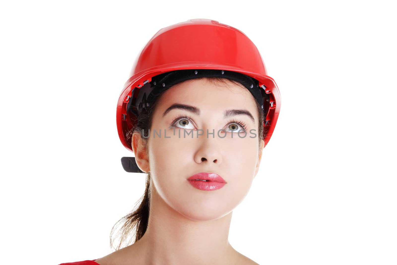 Portrait of confident female worker in helmet looking up. Isolated on white