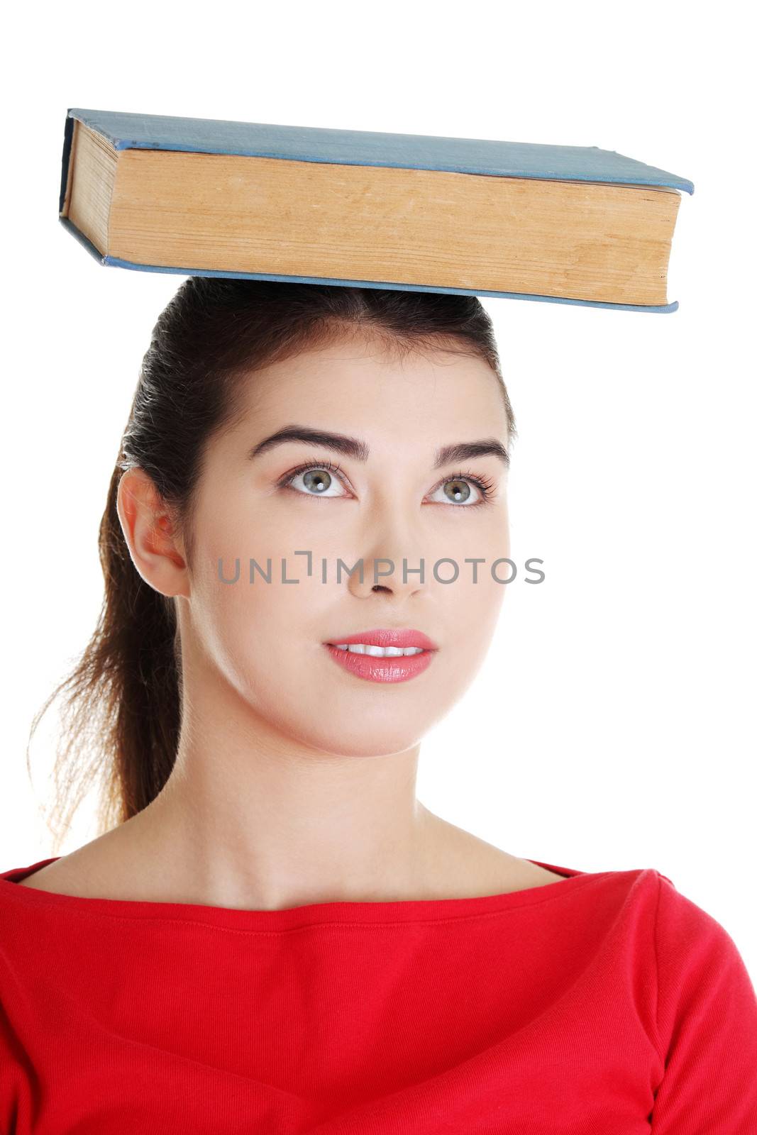 Young caucasian woman (student) with book on her head