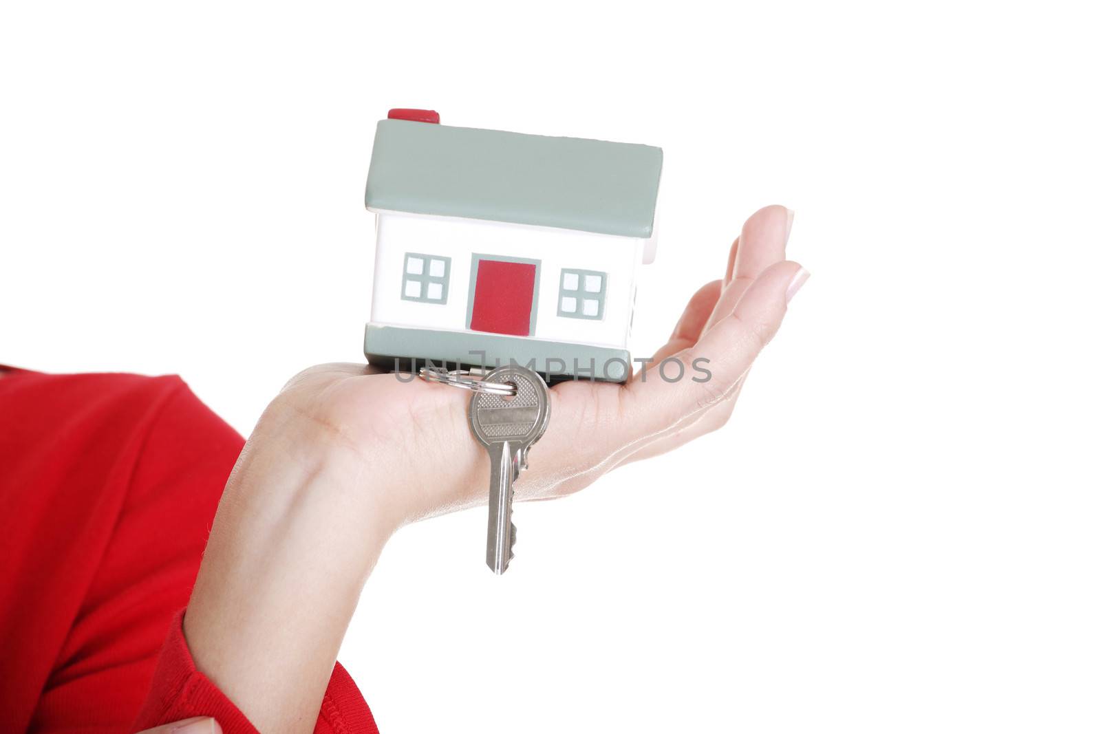 Hand holding a house key. Isolated on white background.