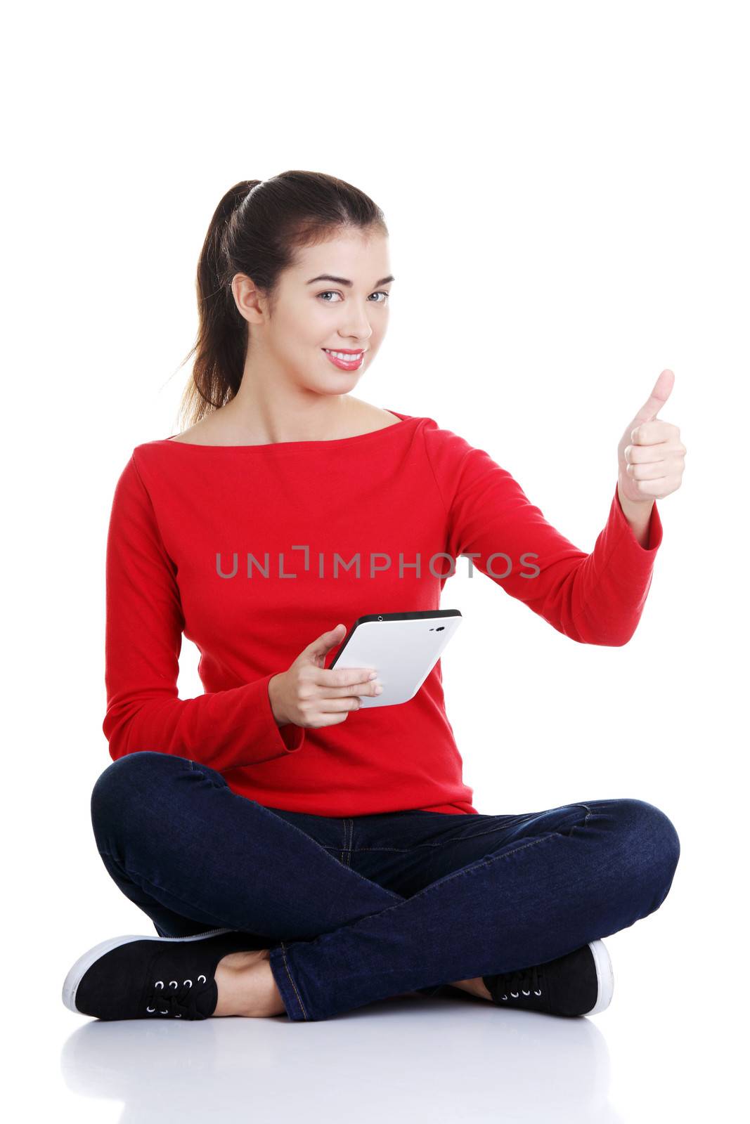 Young pretty woman sitting and working on tablet computer, isolated on white