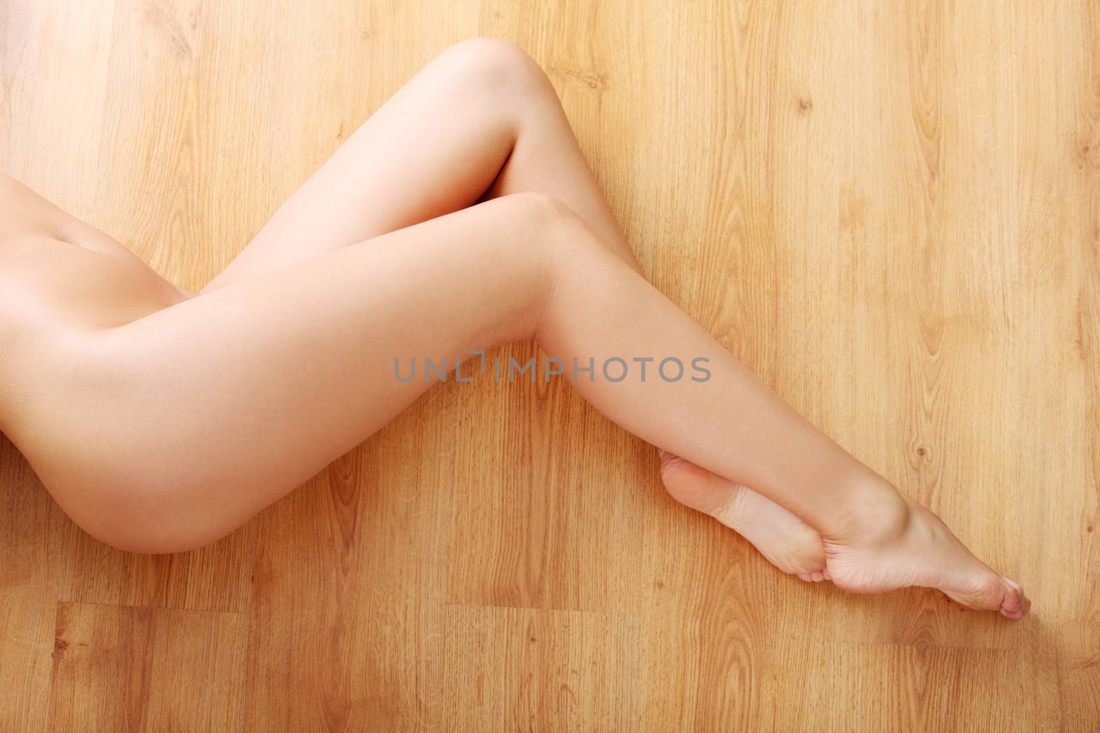 Sexy nude woman body (legs) on wooden flor