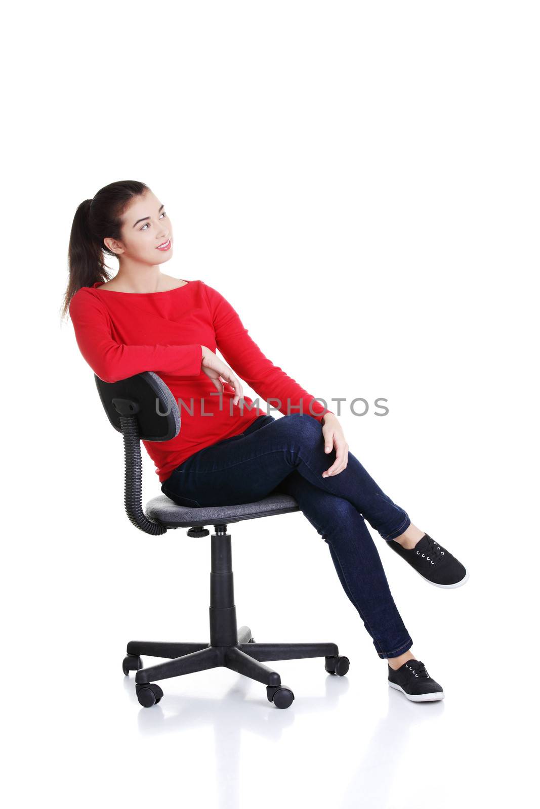 Young happy woman sitting on a wheel chair, isolated over a white background