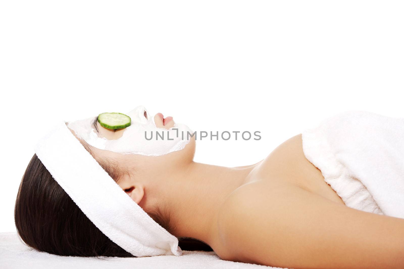 Young woman with cucumber slices on the face in a spa saloon