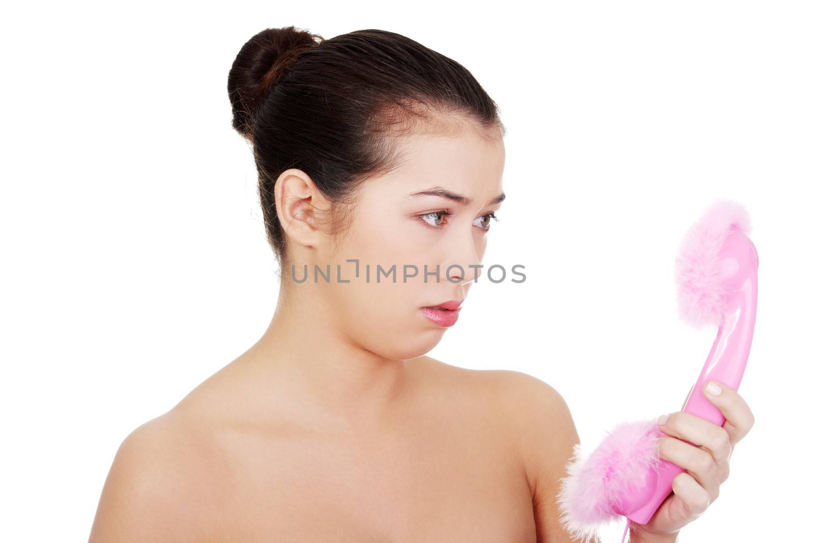 Disappointed woman looking on pink handset, isolated on white