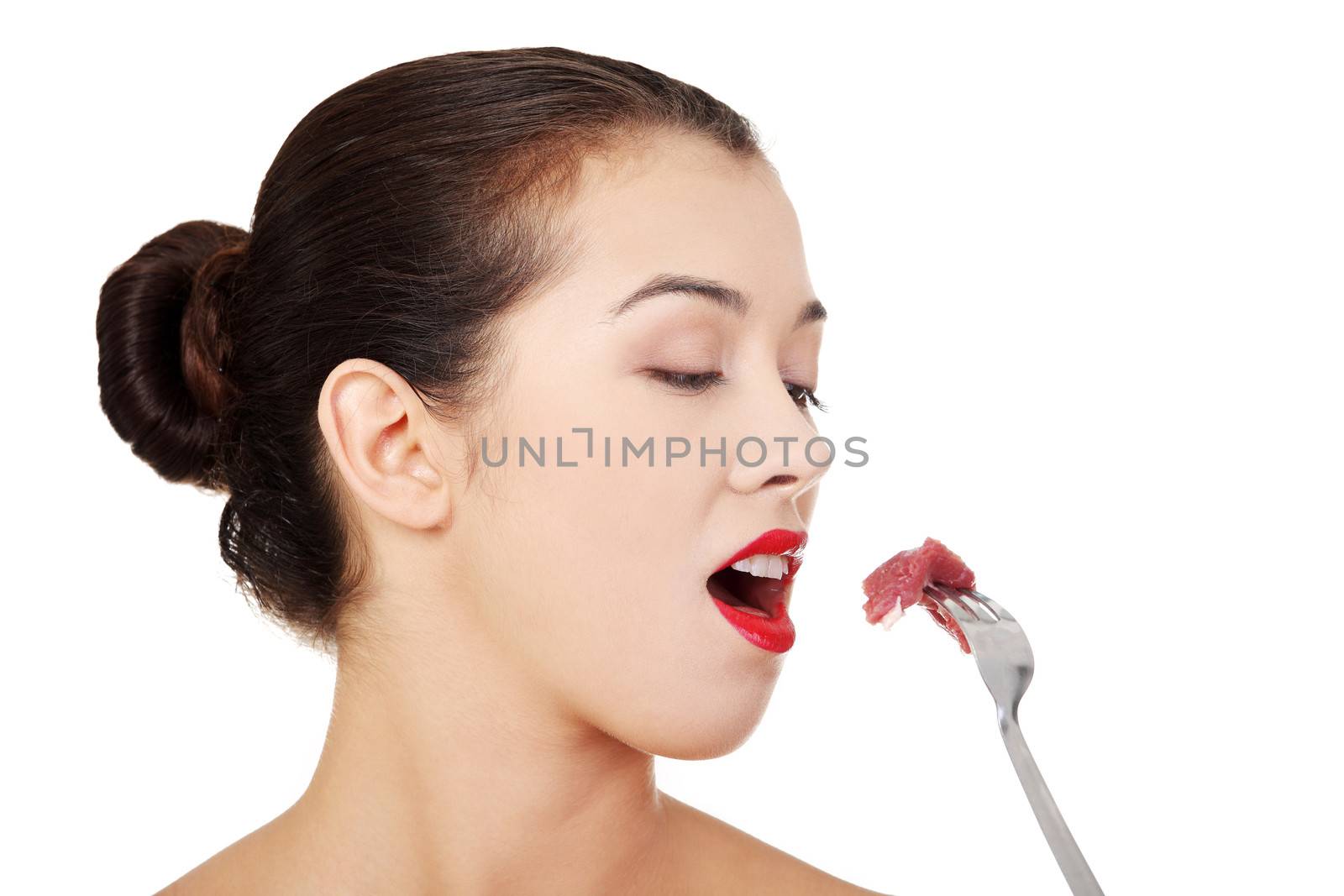 Young beautiful woman eating raw meat. by BDS