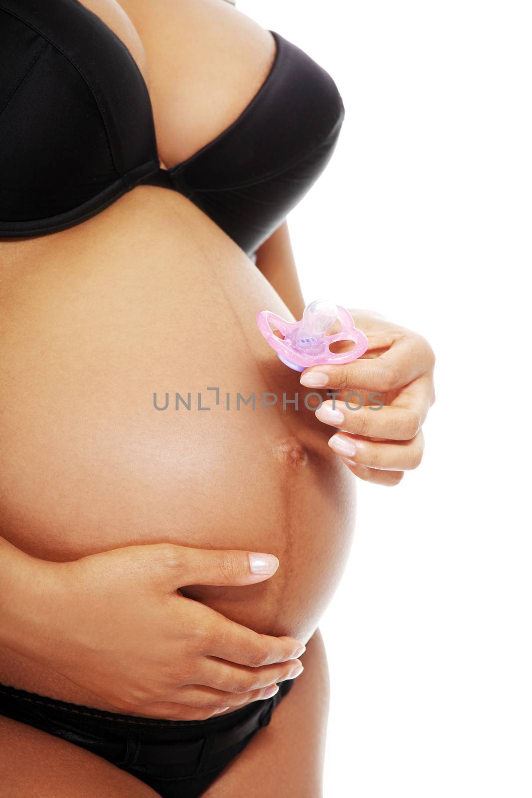 Beautiful pregnant woman holding a pink dummy next to her belly