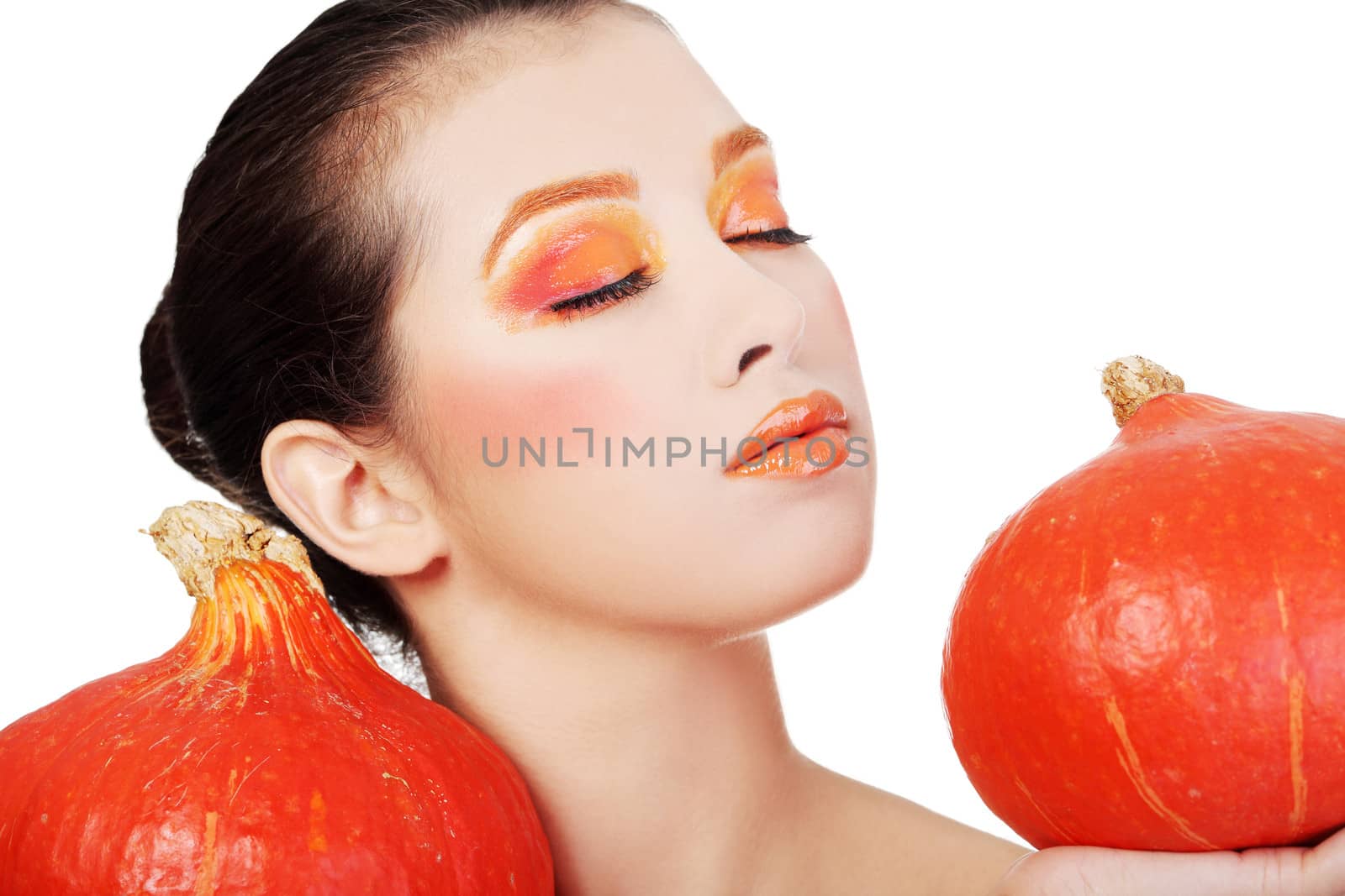 Beautiful woman with orange make up holding pumpkin. Isolated on white