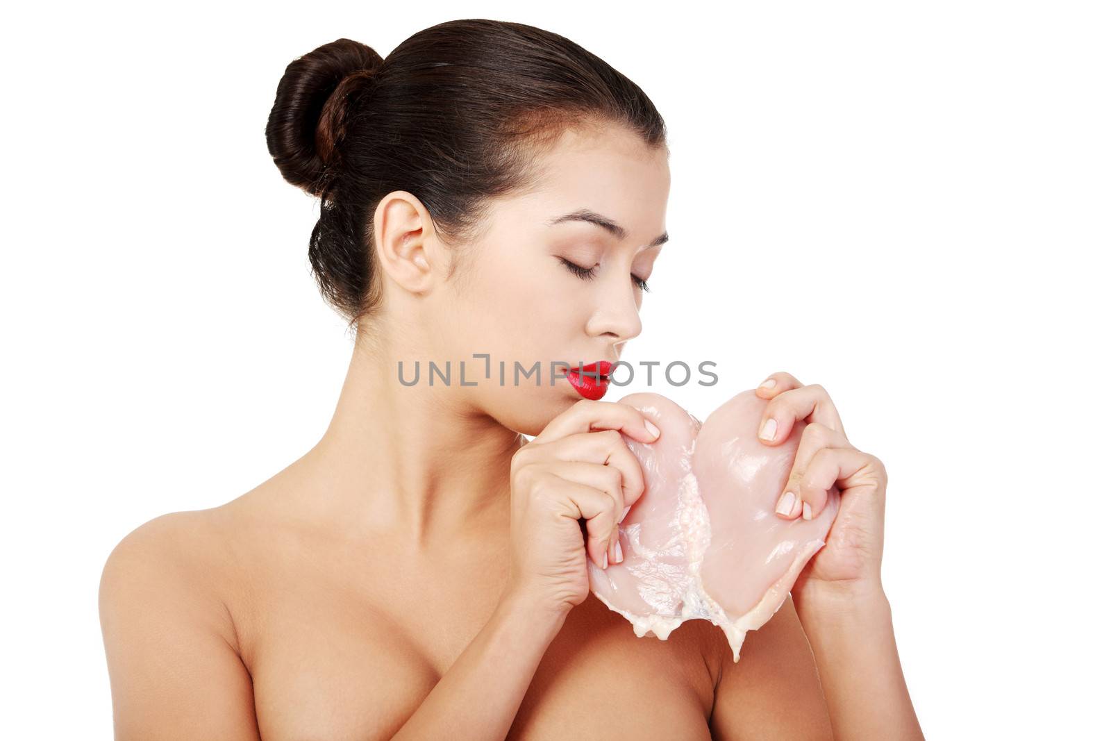 Young beautiful woman eating raw meat. by BDS