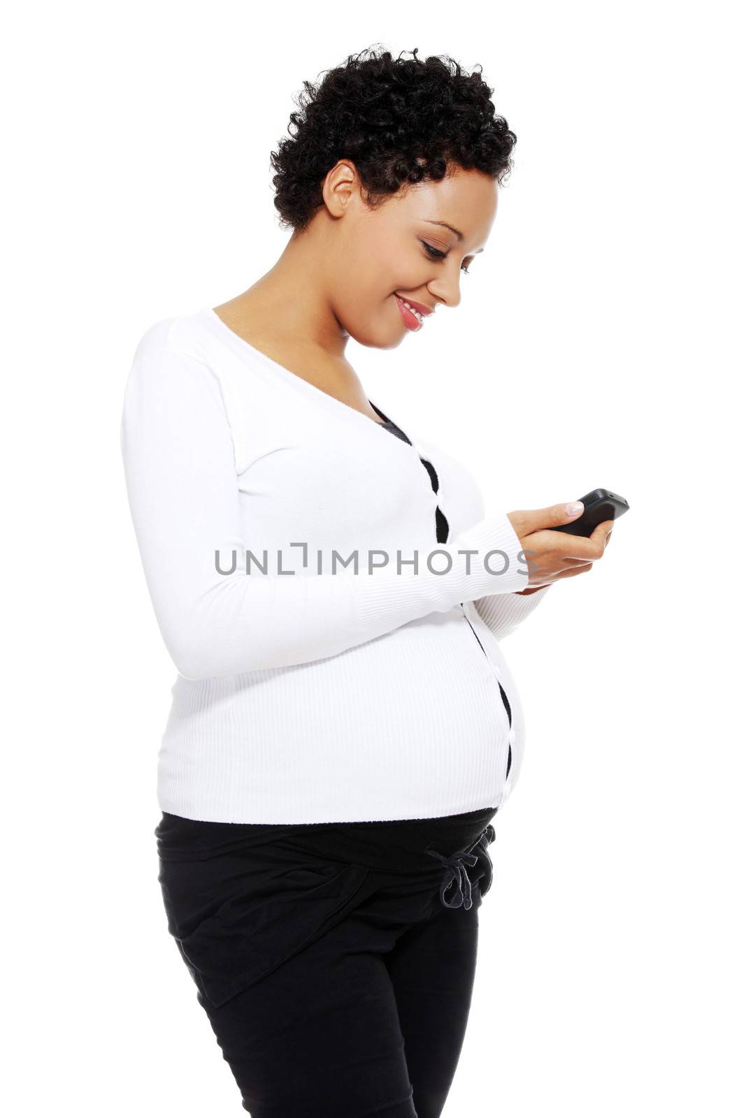 Beautiful pregnant woman dialing a number on her cellphone, isolated on a white background.