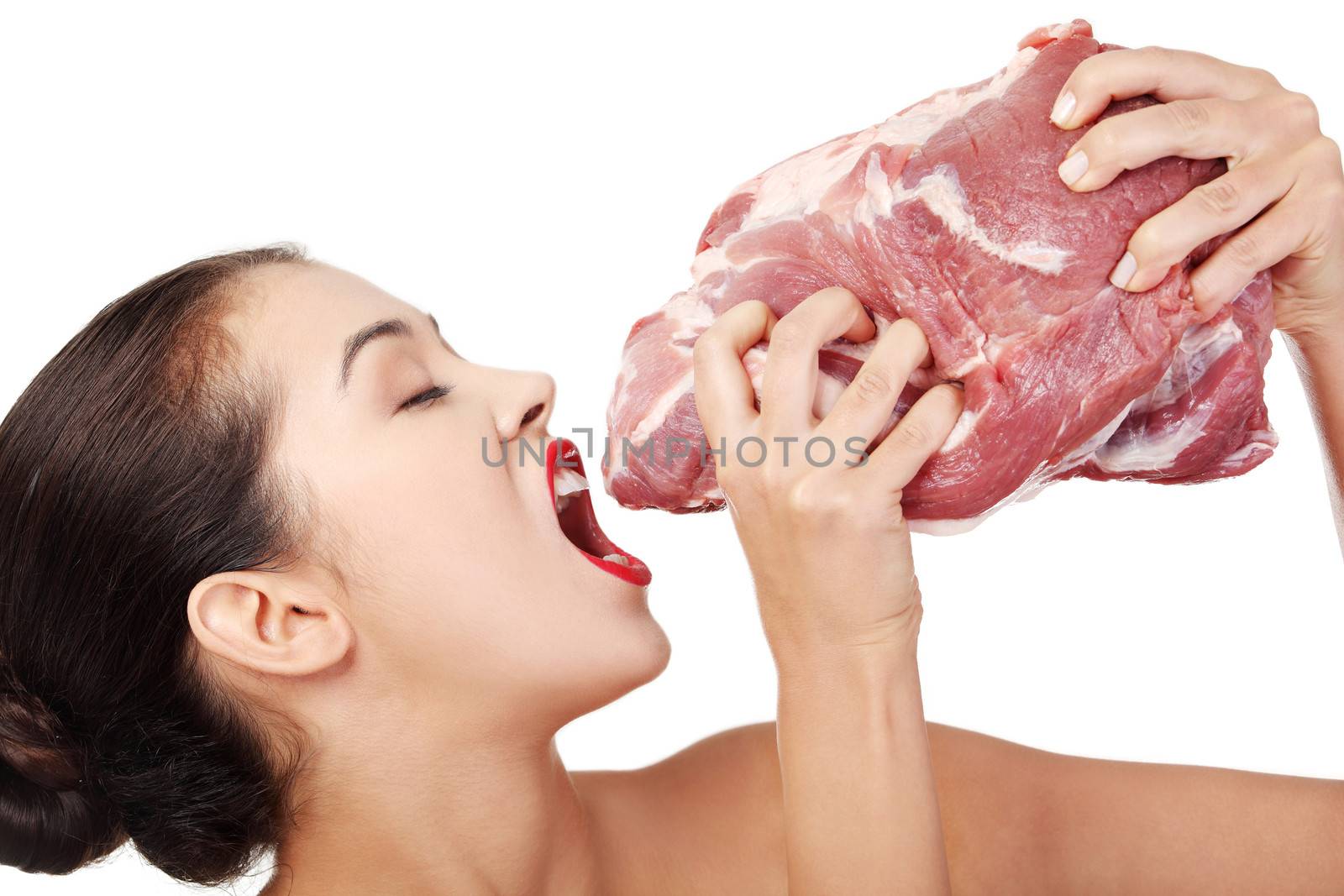 Young beautiful woman eating raw meat. by BDS