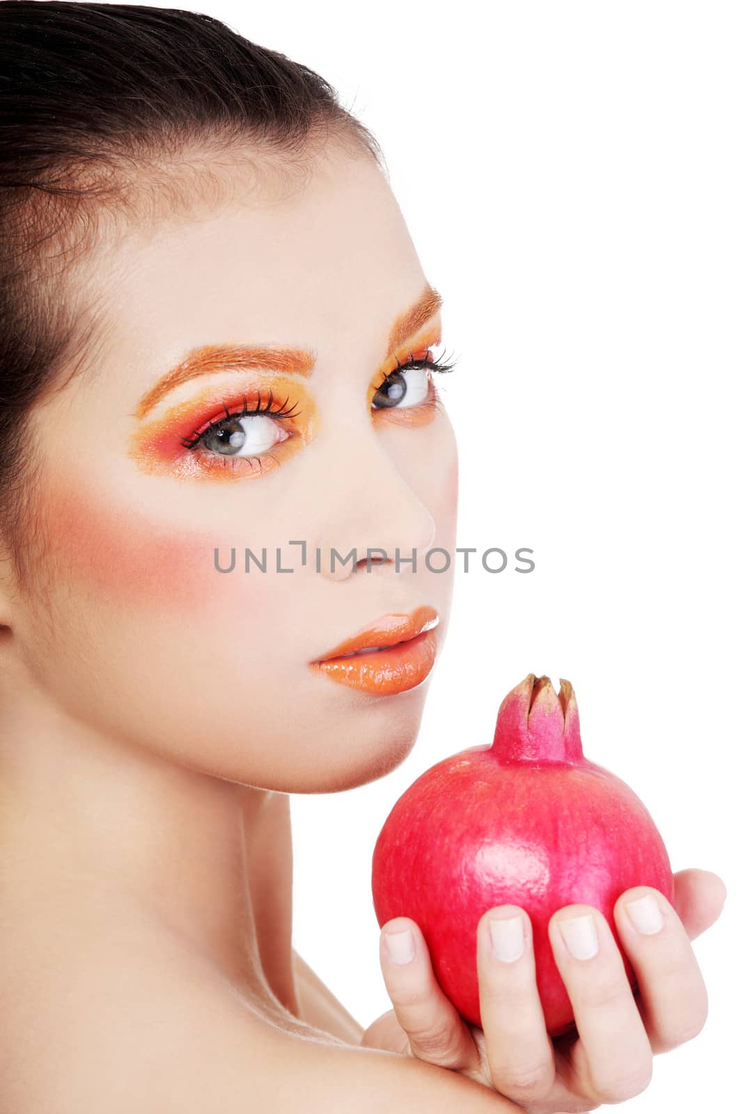 Portrait of young beautiful woman with pomegranates in her hands, on white background