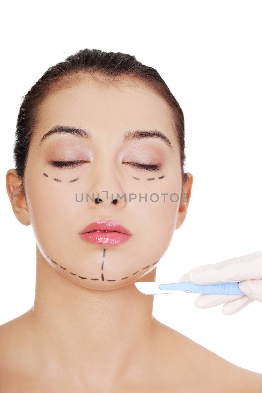 Cosmetic surgery concept. Female face in background of scalpel.