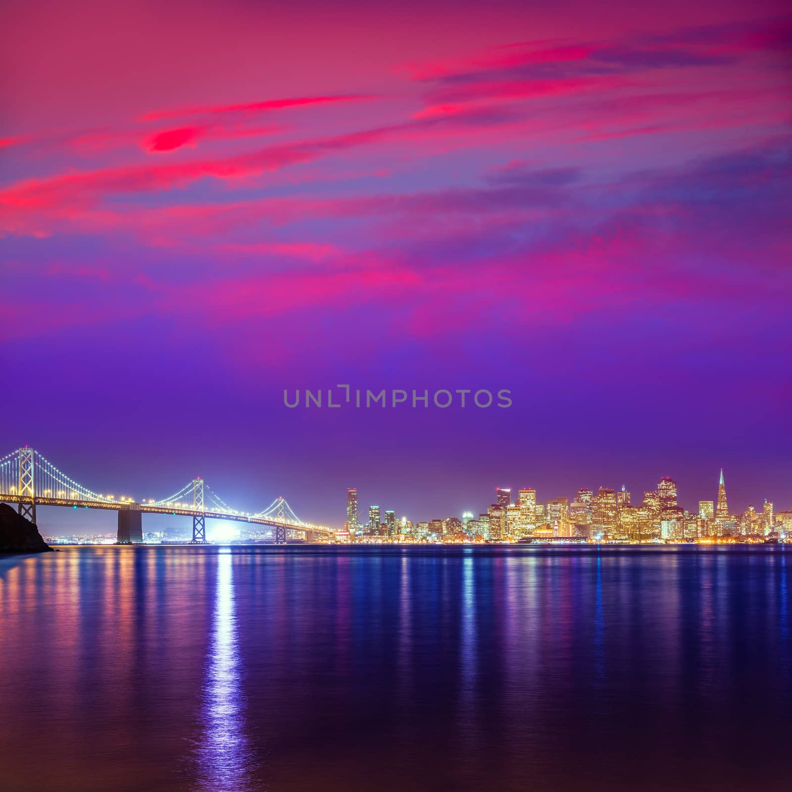 San Francisco sunset skyline and Bay Bridge in California with reflection in bay water USA