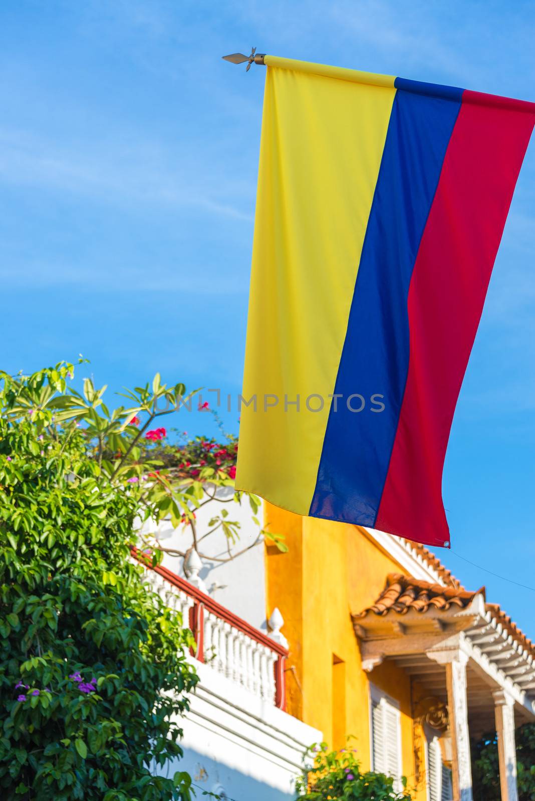 View of the Colombian flag with colonial architecture and blue sky in Cartagena, Colombia