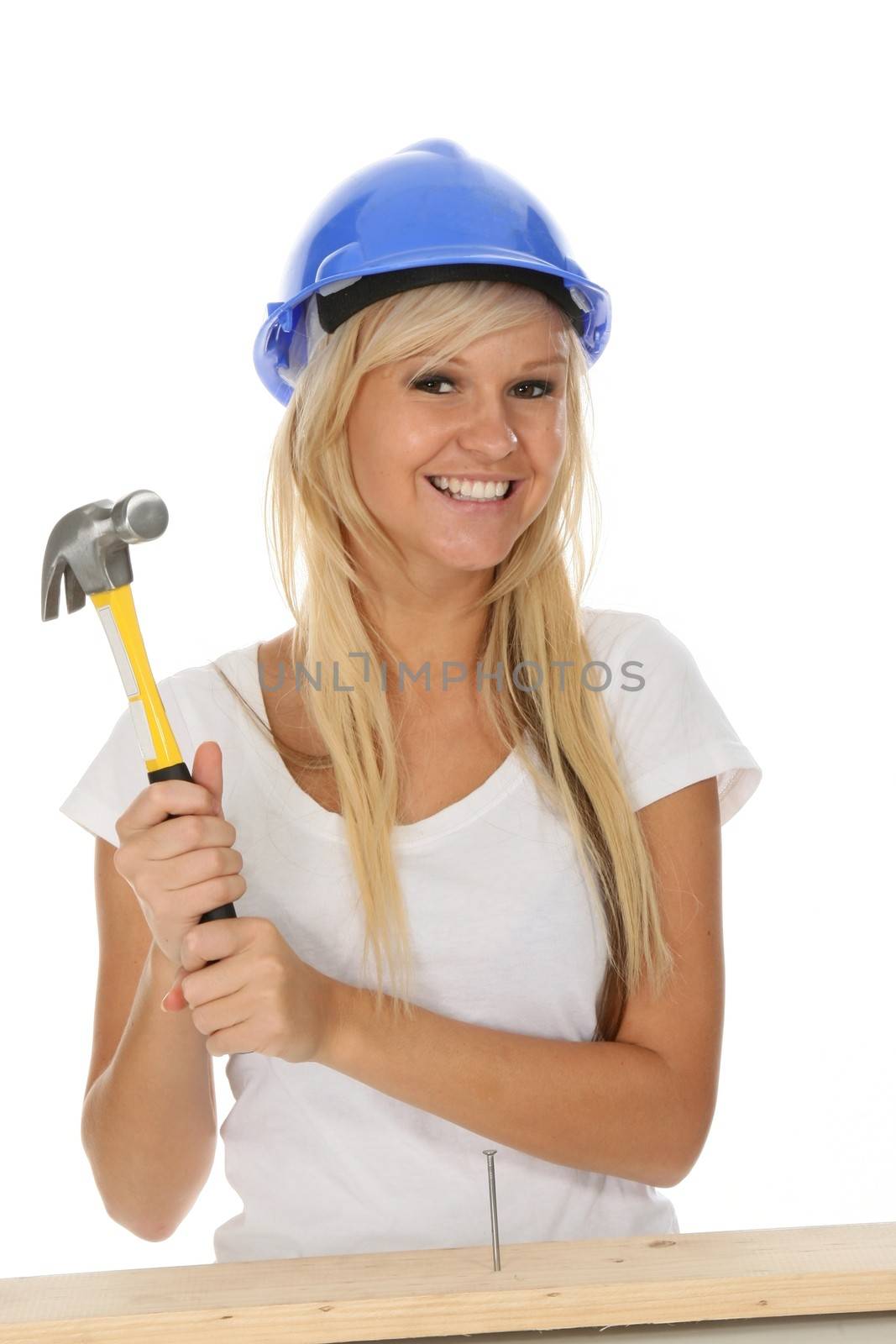 Lovely blond lady hammering in a nail into timber