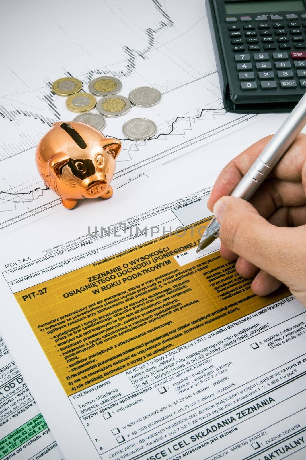 Man hand filling PIT-37 income tax forms with calculator and coi by simpson33